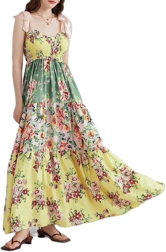A woman wearing a long, floral maxi dress with pastel colors and ruffled straps.