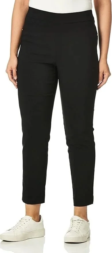 Person wearing black pants and white sneakers against a plain background.
