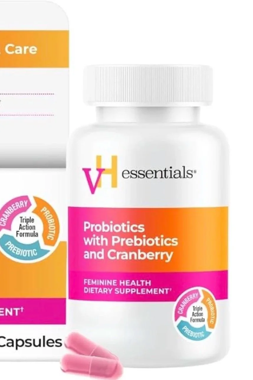 White bottle of VH essentials probiotics with prebiotics and cranberry dietary supplement, featuring pink capsules and a label with pink, orange, yellow, blue, and black text.
