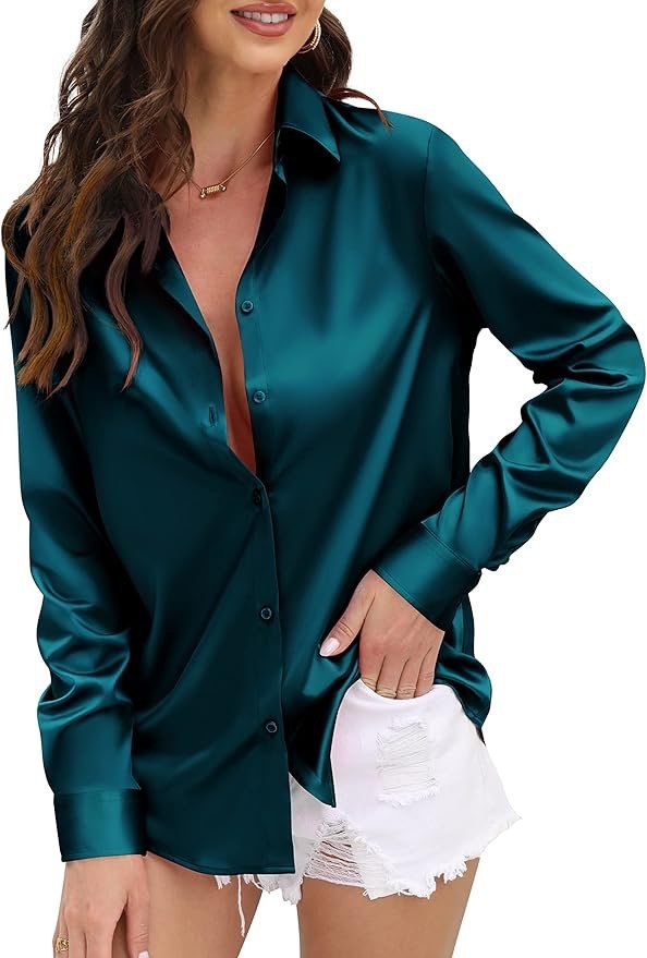 A woman wearing a teal satin button-up shirt and white ripped denim shorts.