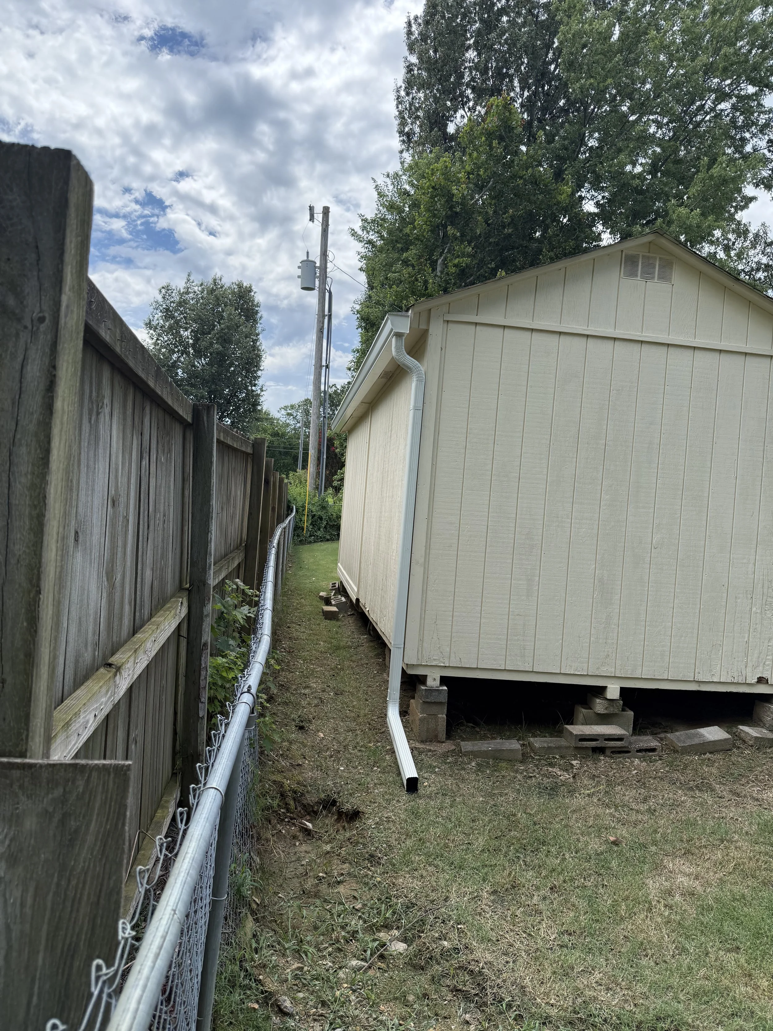 White seamless gutters installed on a workshop in Olive Branch, MS, providing dependable rainwater drainage and a clean finished appearance.