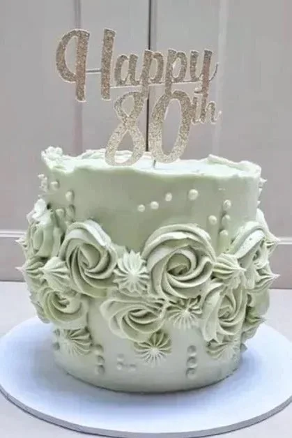 Elegant 80th birthday cake with pale sage green buttercream piping swirl detailing, and edible pearls. Made by bespoke Warwickshire cake designer Bloon & Co.
