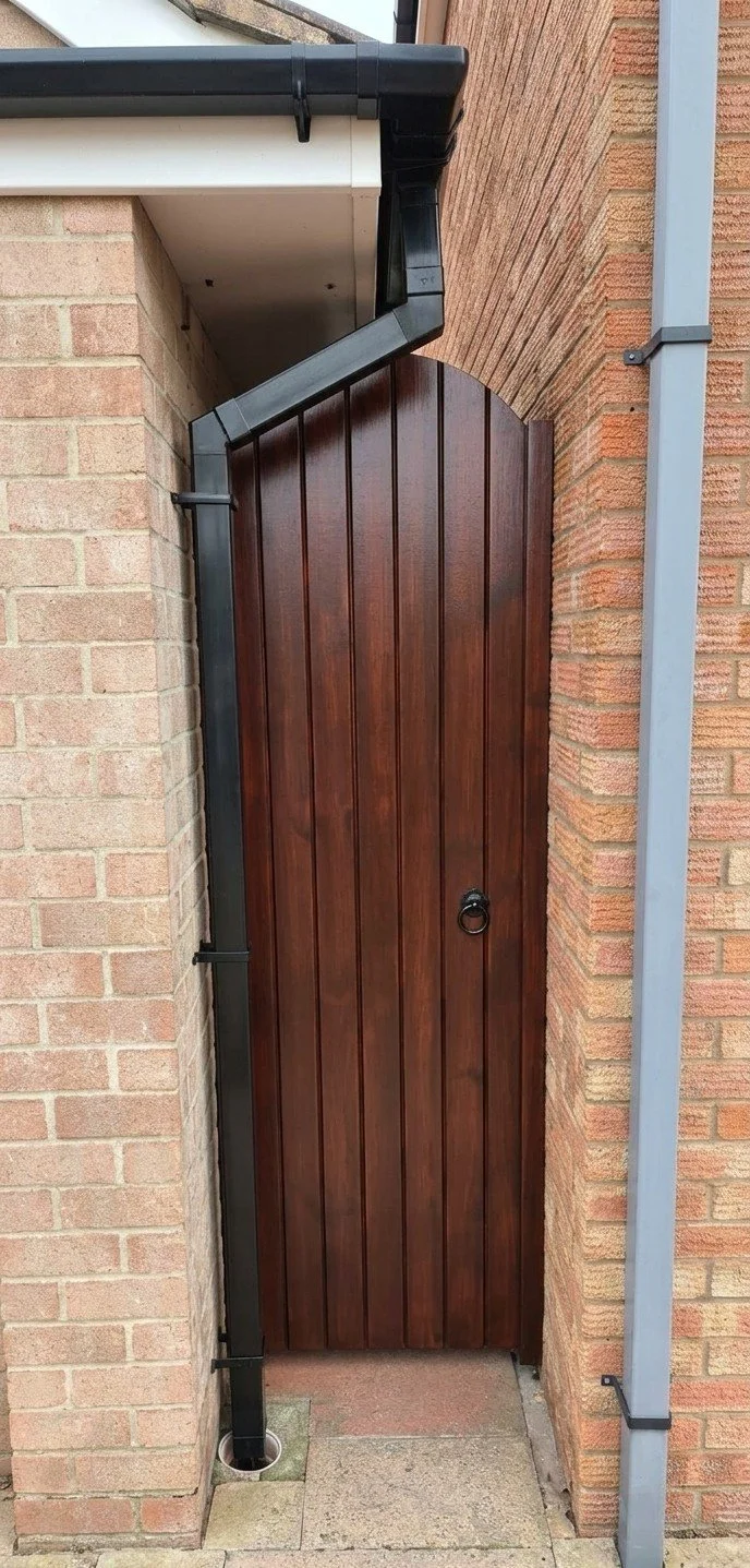 Custom Arched Gate: Handmade from treated softwood. Deep mahogany stain. Precision-fitted to existing masonry and drainage.