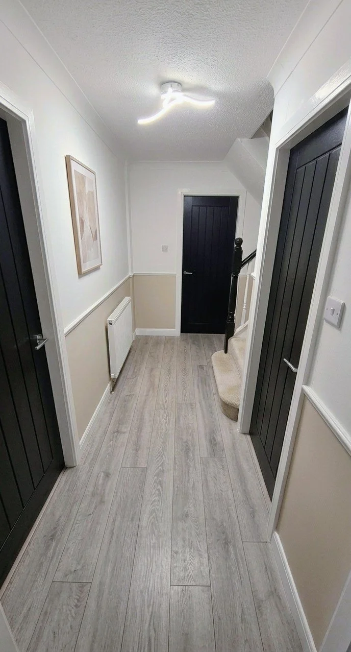 Full Hallway Fit-Out: Contemporary dark-panelled internal doors. Wide-plank oak-effect flooring. Precision architraves and finishing.