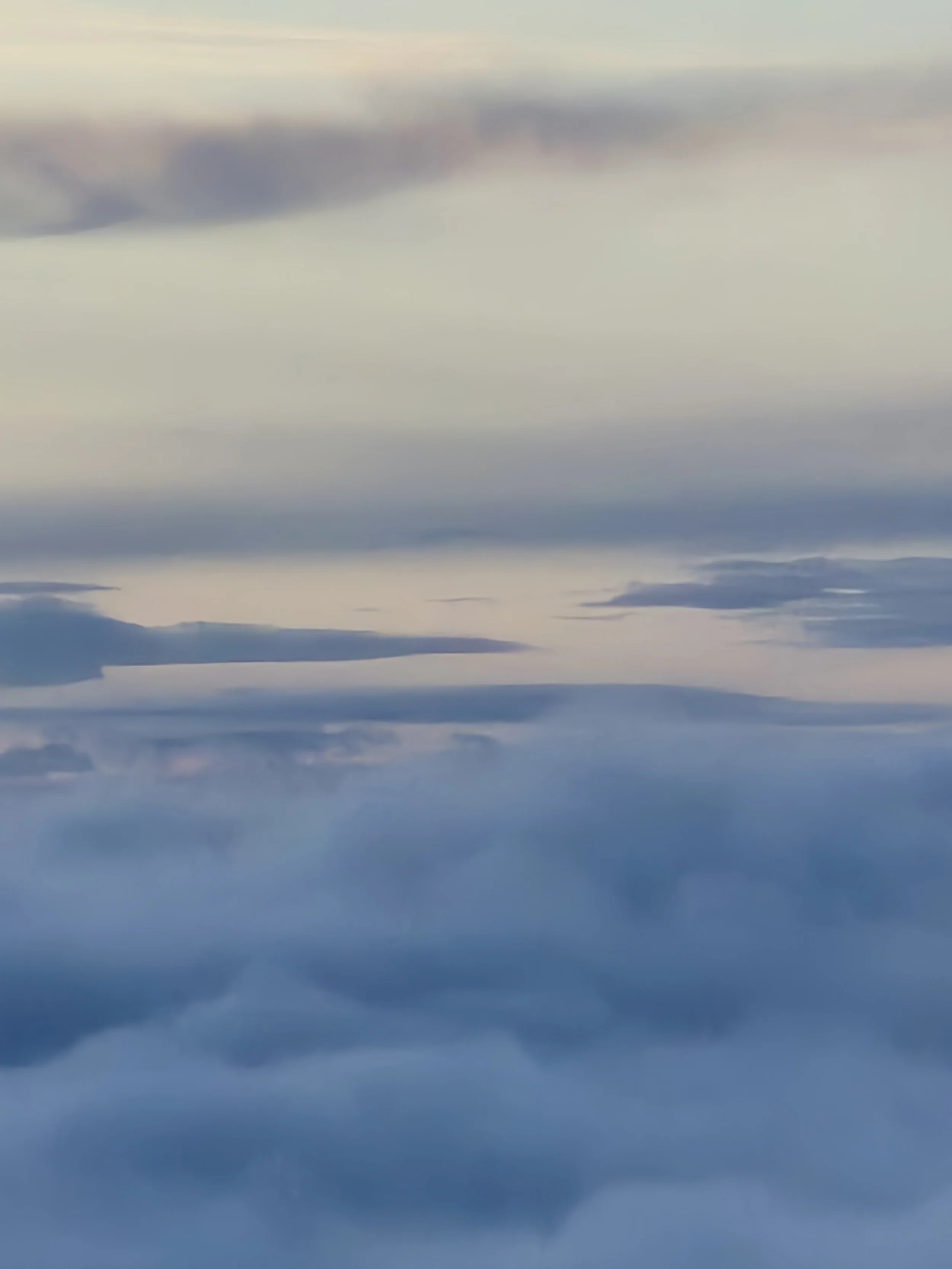 A sky filled with clouds of varying shades of white, gray, and blue, creating a serene and calm atmosphere during daytime.