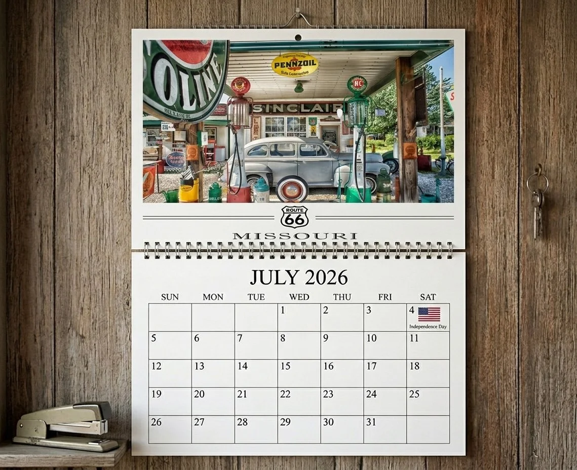A wall calendar for July 2026 with a photo of an vintage gas station scene, including a gray car, gas pumps, and various nostalgic signs and decorations in Missouri.