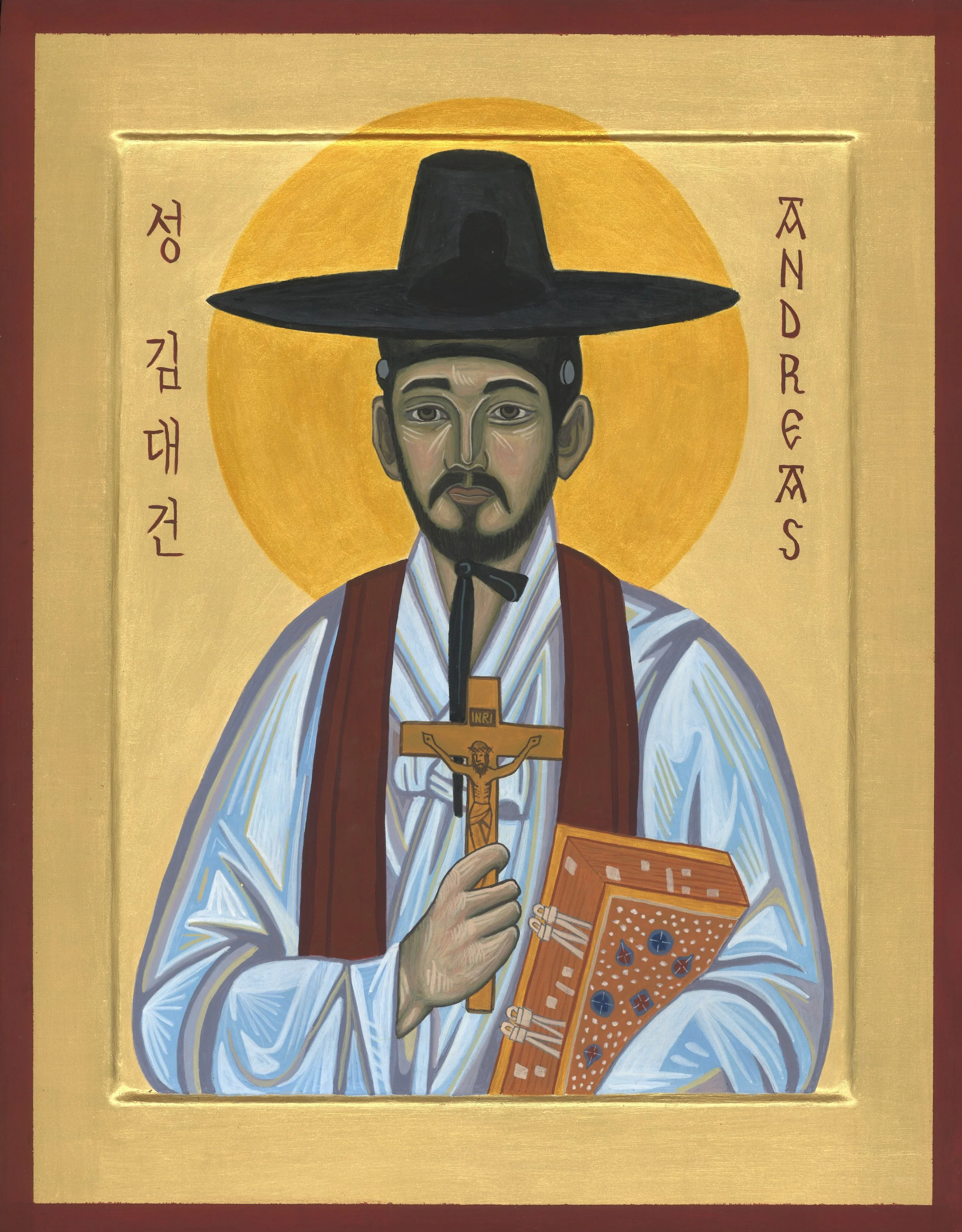 An icon of St. Andrew Kim Taegon wearing traditional Korean clothing, a wide-brimmed hat, and holding a crucifix and a decorated book, with Korean and Latin text surrounding the figure.