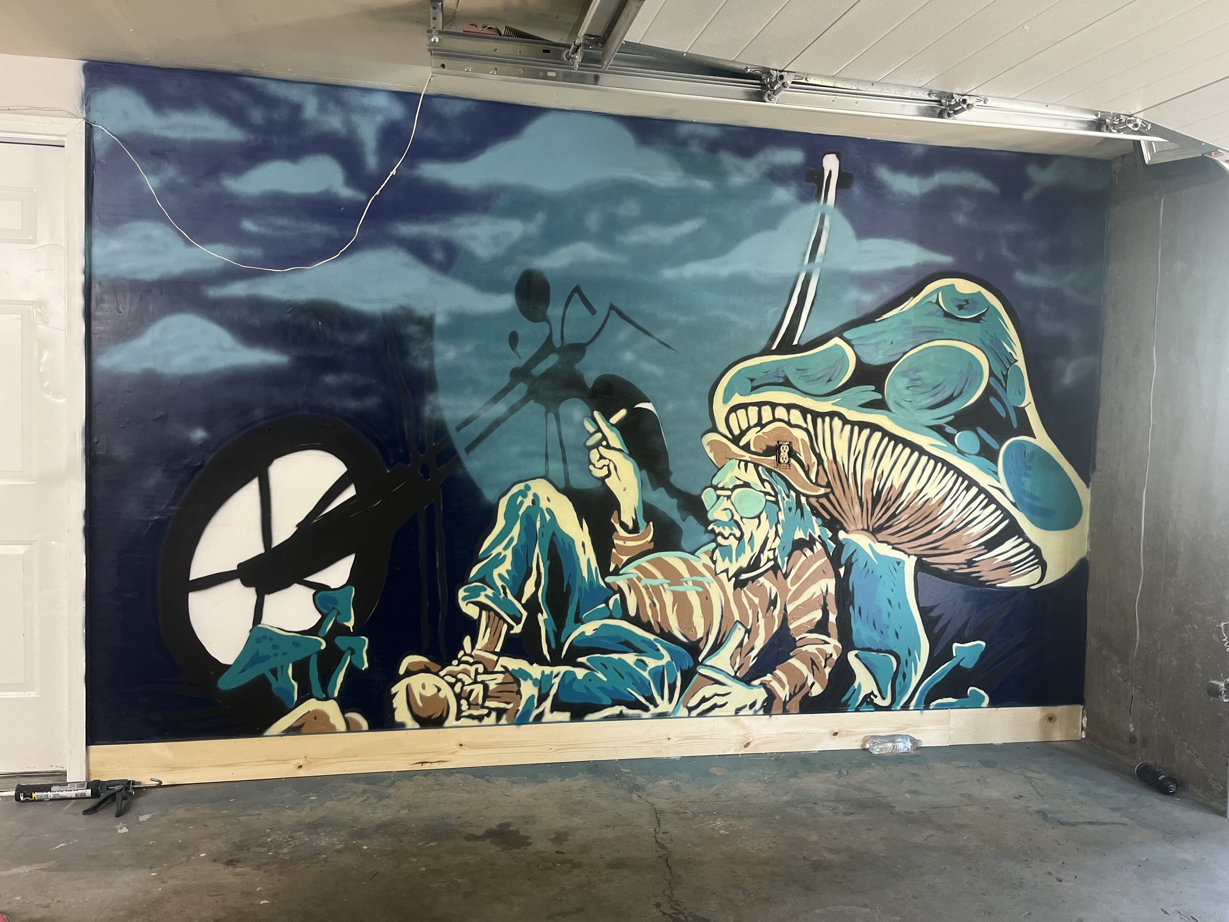 A colorful mural depicting a fierce dragon with blue, gold, and black colors, with a background of cloudy sky in shades of blue and white.