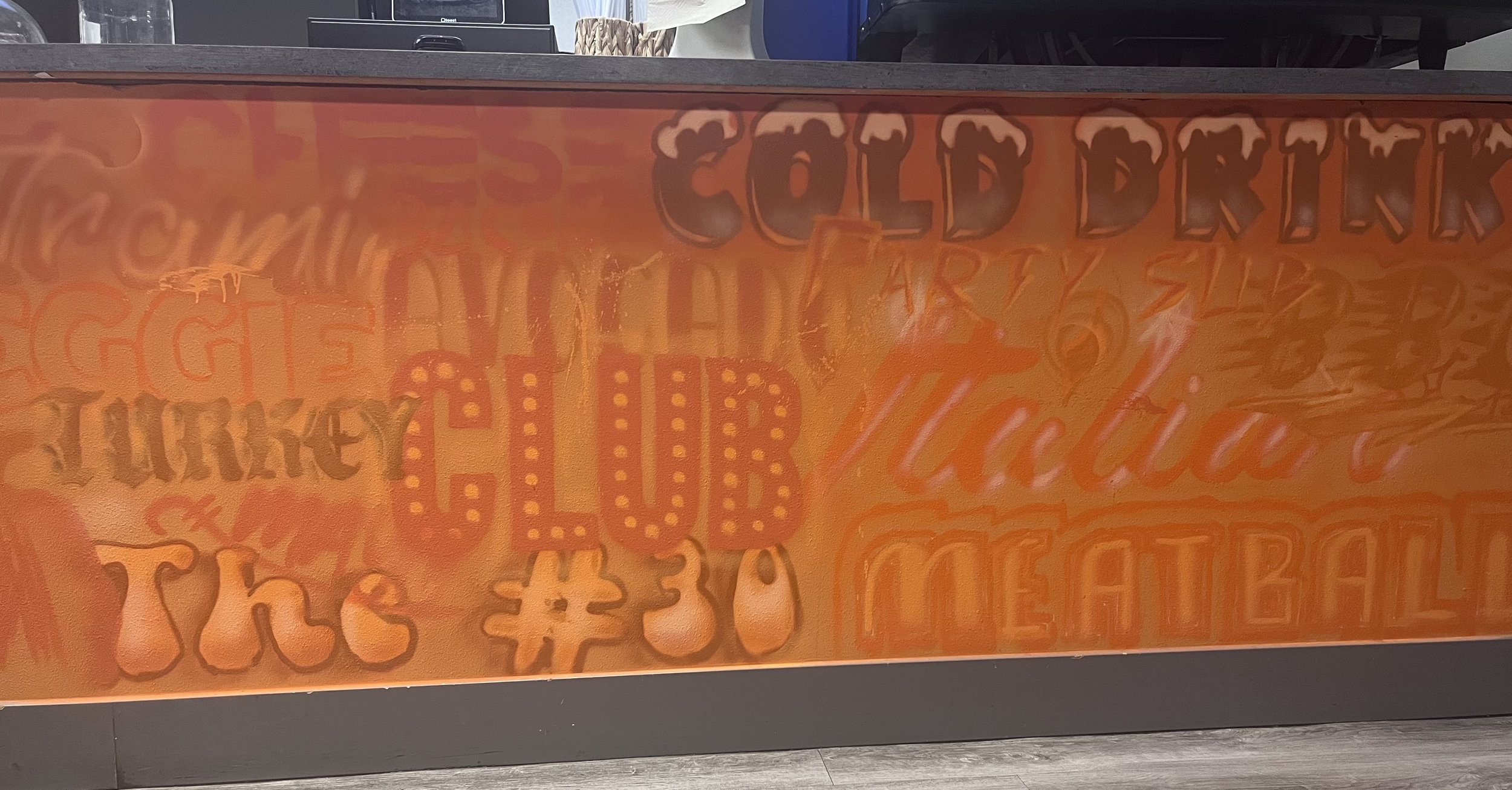 An orange-colored poster with various Halloween-themed words and symbols, including pumpkins, bats, and the phrase 'COLD BR'.