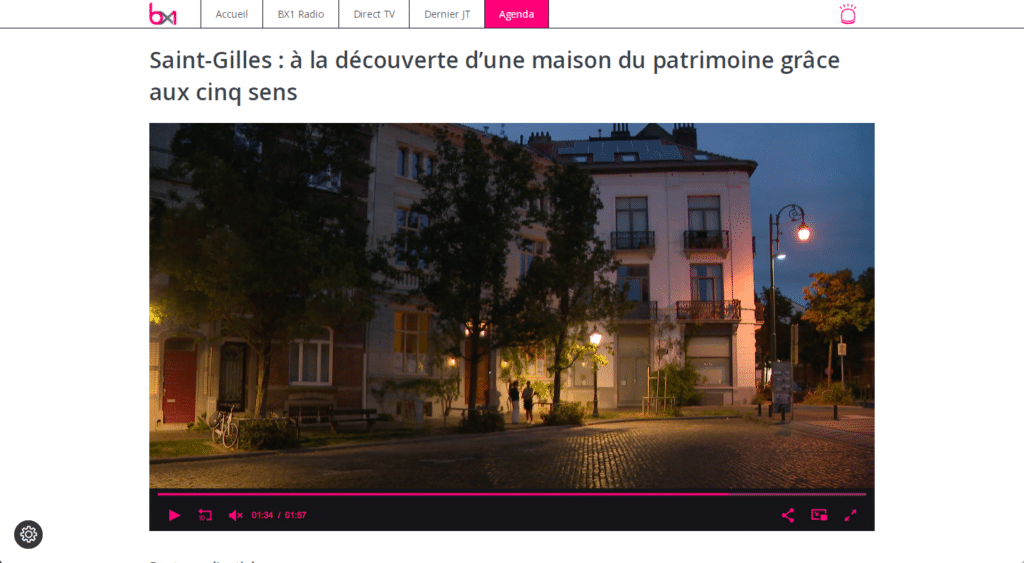 Nighttime street scene in Saint-Gilles showing a historic house with illuminated windows and surrounding trees and street lamps.