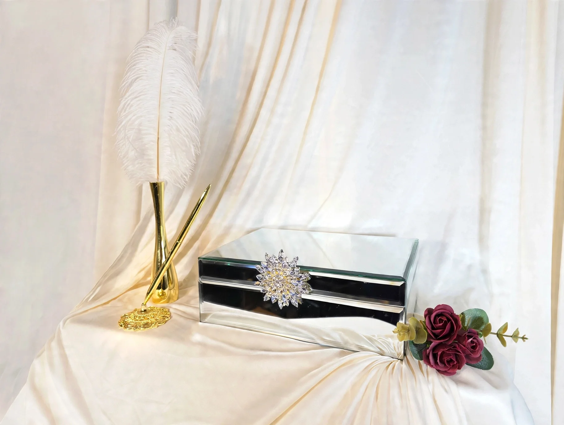 Gold pen with ornate base and mirrored gift card box with crystal accent and roses on cream fabric