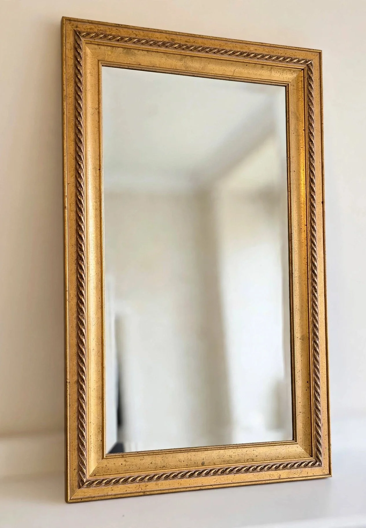 Rectangular mirror with ornate gold frame featuring rope‑style detailing on inner edge