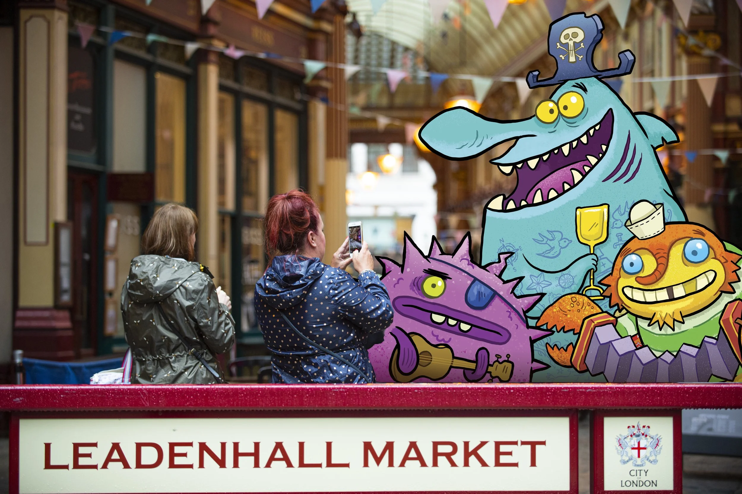 People taking photos in front of a colorful cartoon monster display at Leadenhall Market in London.