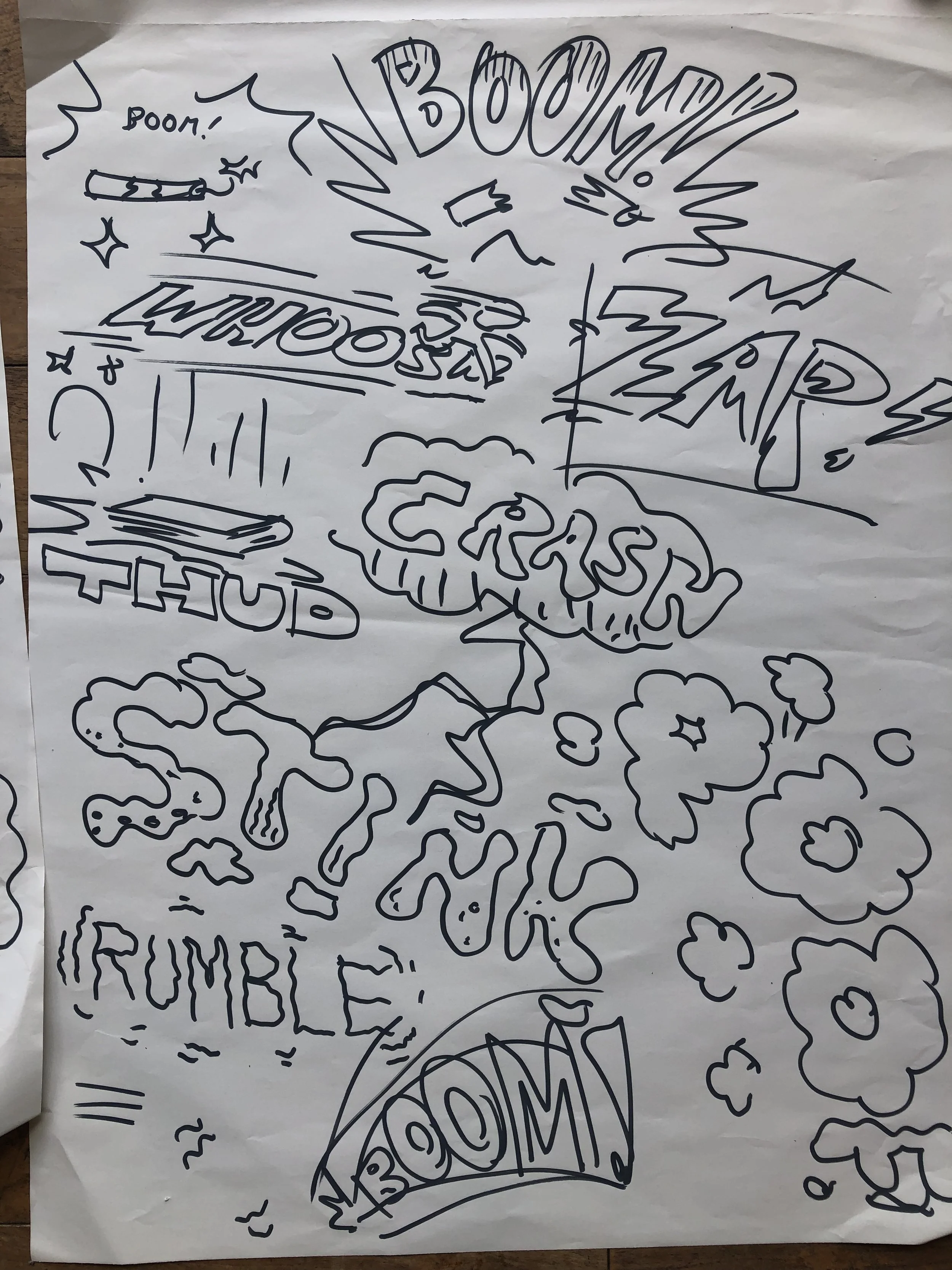 A hand-drawn comic-style illustration with words like 'BOOM!', 'CRASH!', and 'NOOOM!', surrounded by clouds, explosions, and abstract lines, on a crumpled piece of paper.
