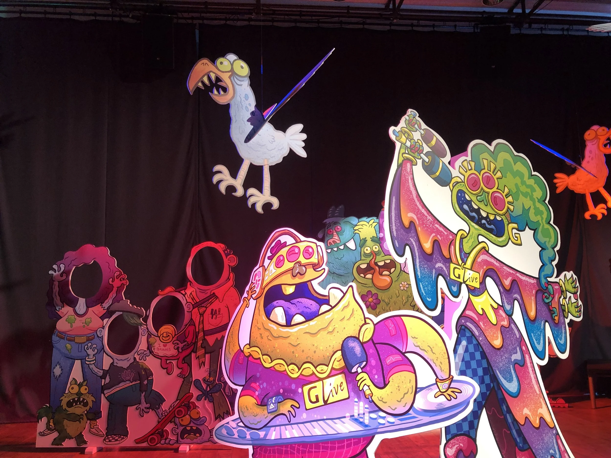 Colorful cartoon characters and animals, including a bird, monsters, and a cake, depicted in a vibrant, playful style.