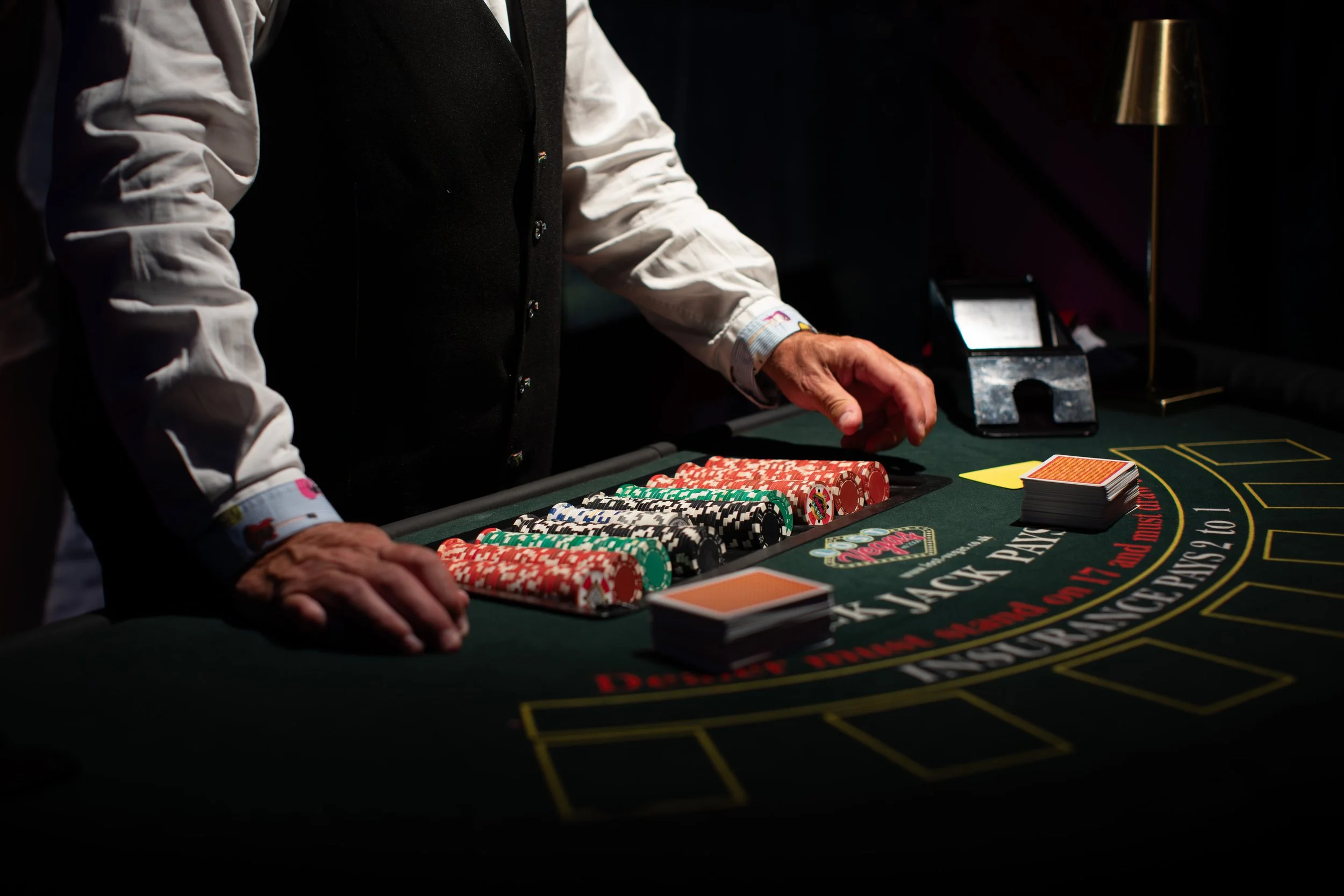 A person placing chips on a blackjack table during a casino game.
