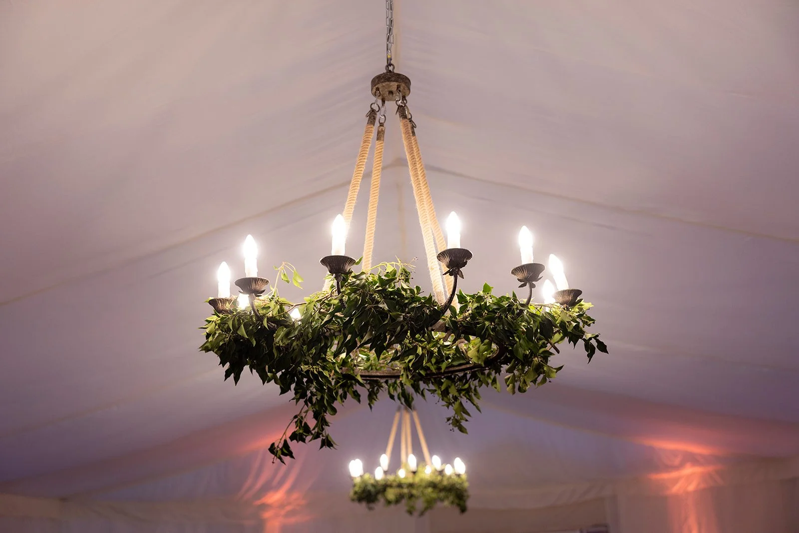 A chandelier decorated with greenery hanging from the ceiling