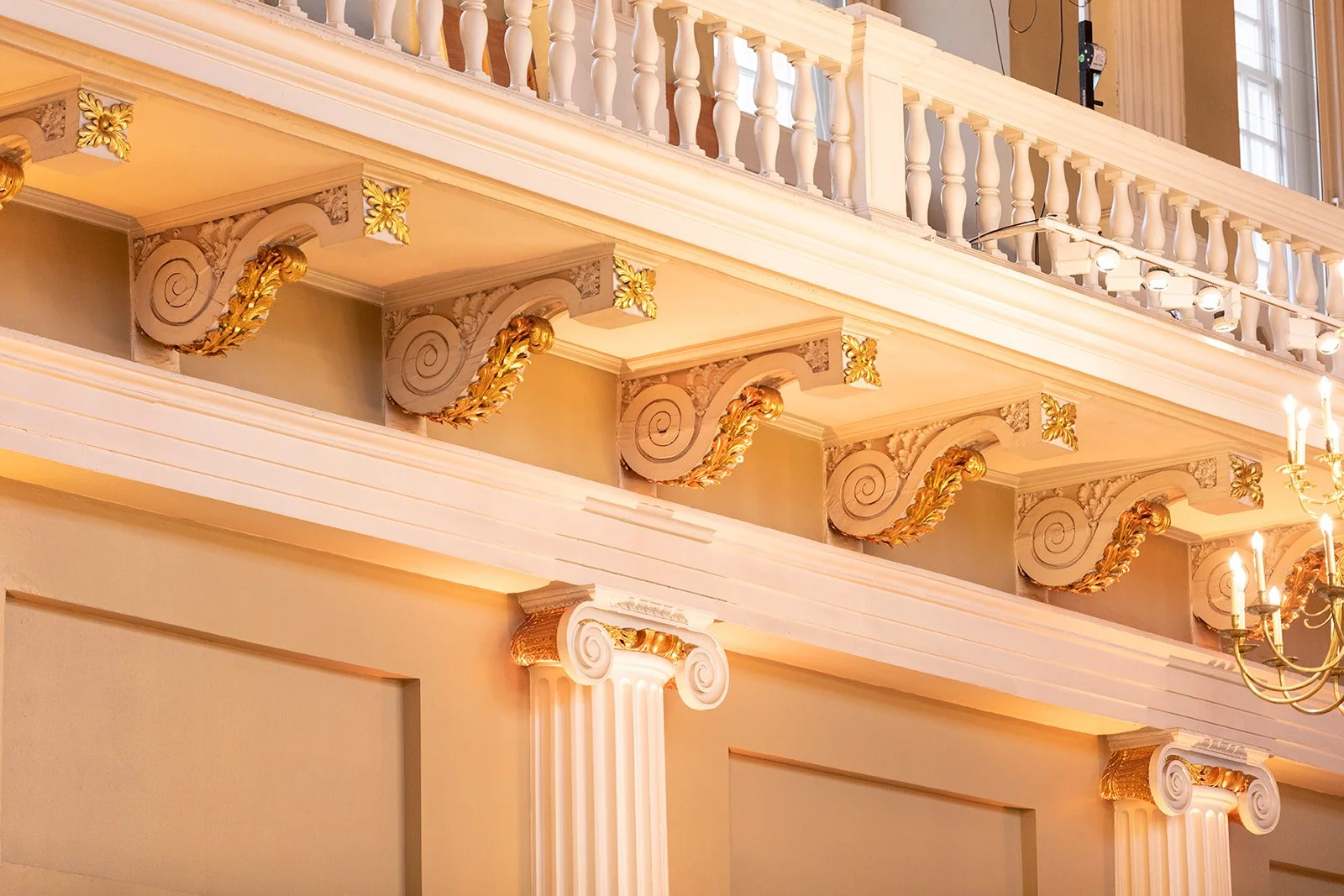 Elegant interior with ornate ceiling, classical columns, and decorative gold leaf accents.