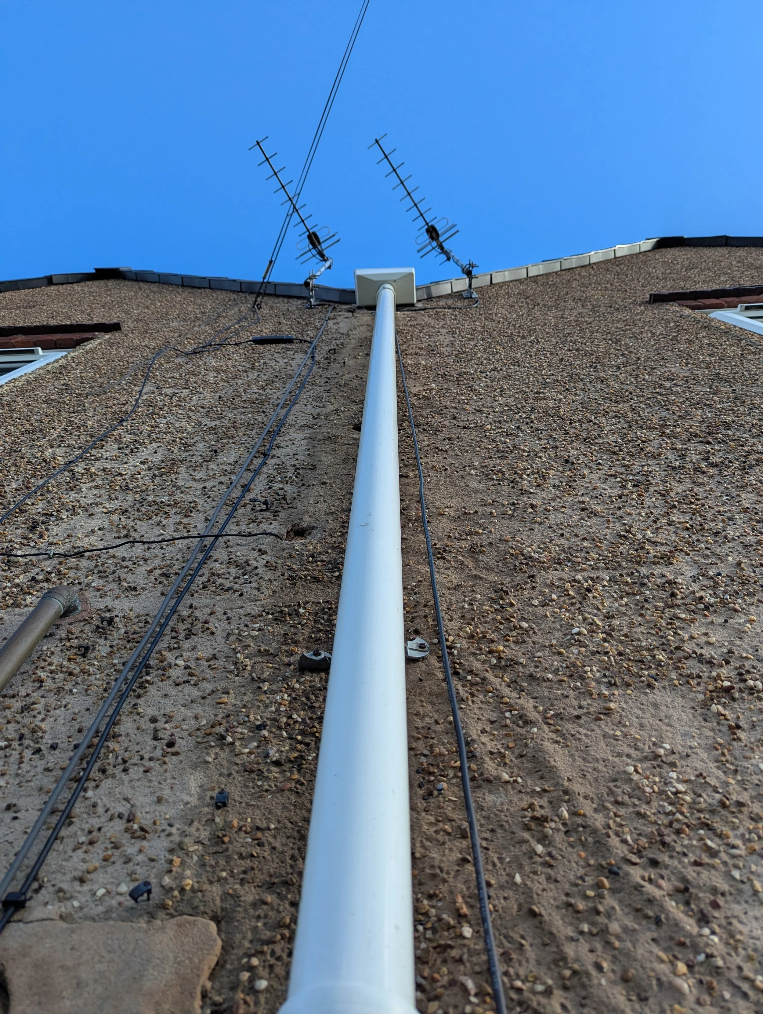 Upward view of a downpipe which has recently been cleaned by Jet Set Wash. This property was green and full of algae. It has now been transformed