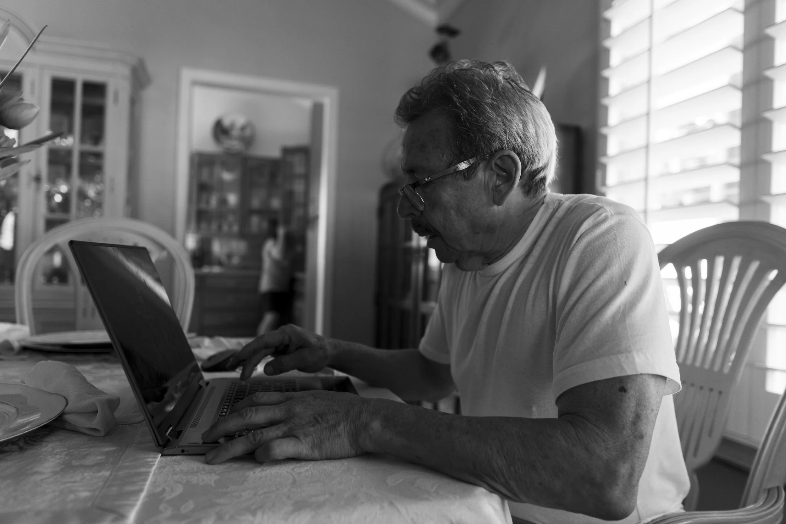 In their home, my grandpa, Juan, sits at the dining table. Here he takes time to practice guitar chords and work on his computer given the leisurely setting of this Sunday afternoon. Through the doorway, my grandma, Teresa, is visible as she organize