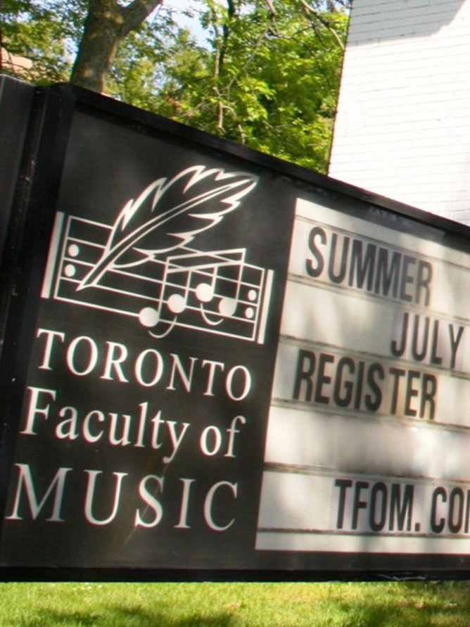 Signboard for Toronto Faculty of Music with a leaf, musical notes, and a keyboard graphic, advertising summer registration in July, with a website TFOAM.COM.