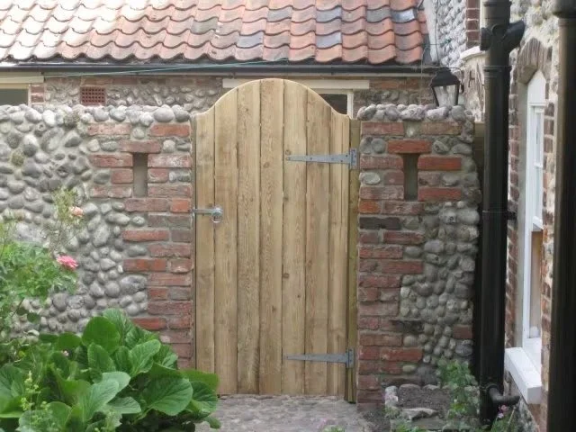 Bespoke gate in wall with cobbles and reclaimed bricks