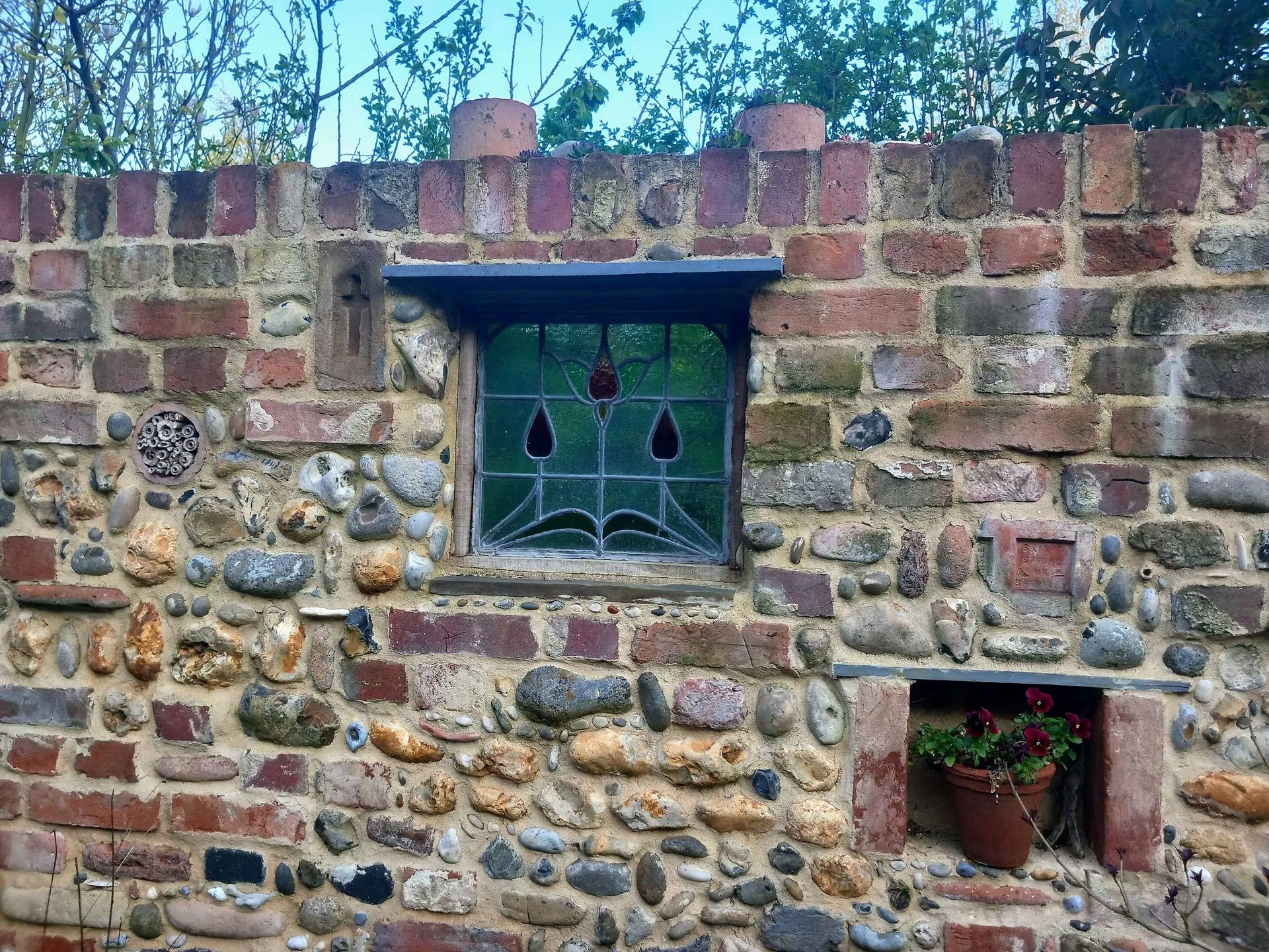 Garden wall made of reclaimed bricks, cobbles and salvaged materials