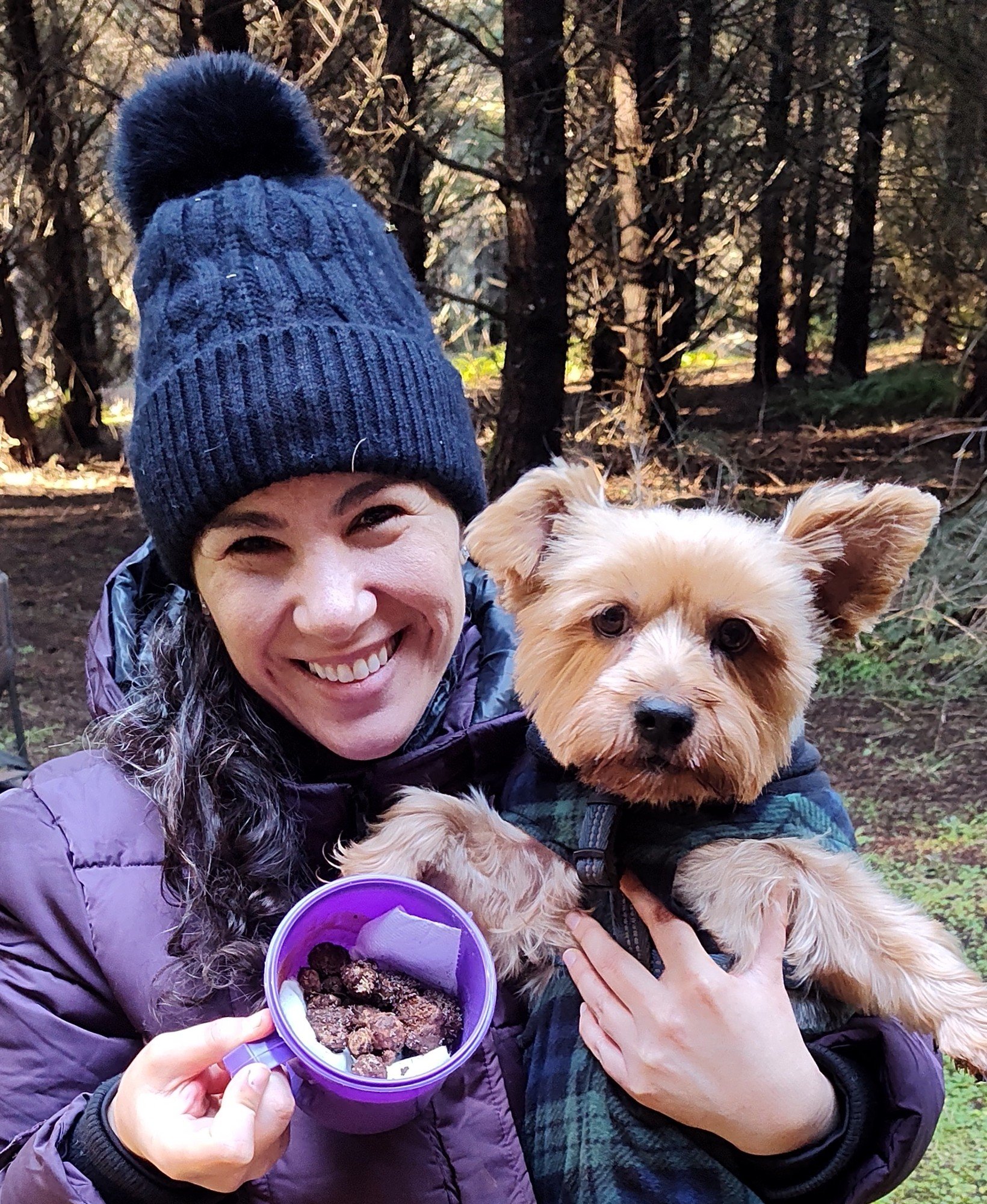 Jessica holding Lizzy Bear and a container of fresh Oregon truffles in the woods