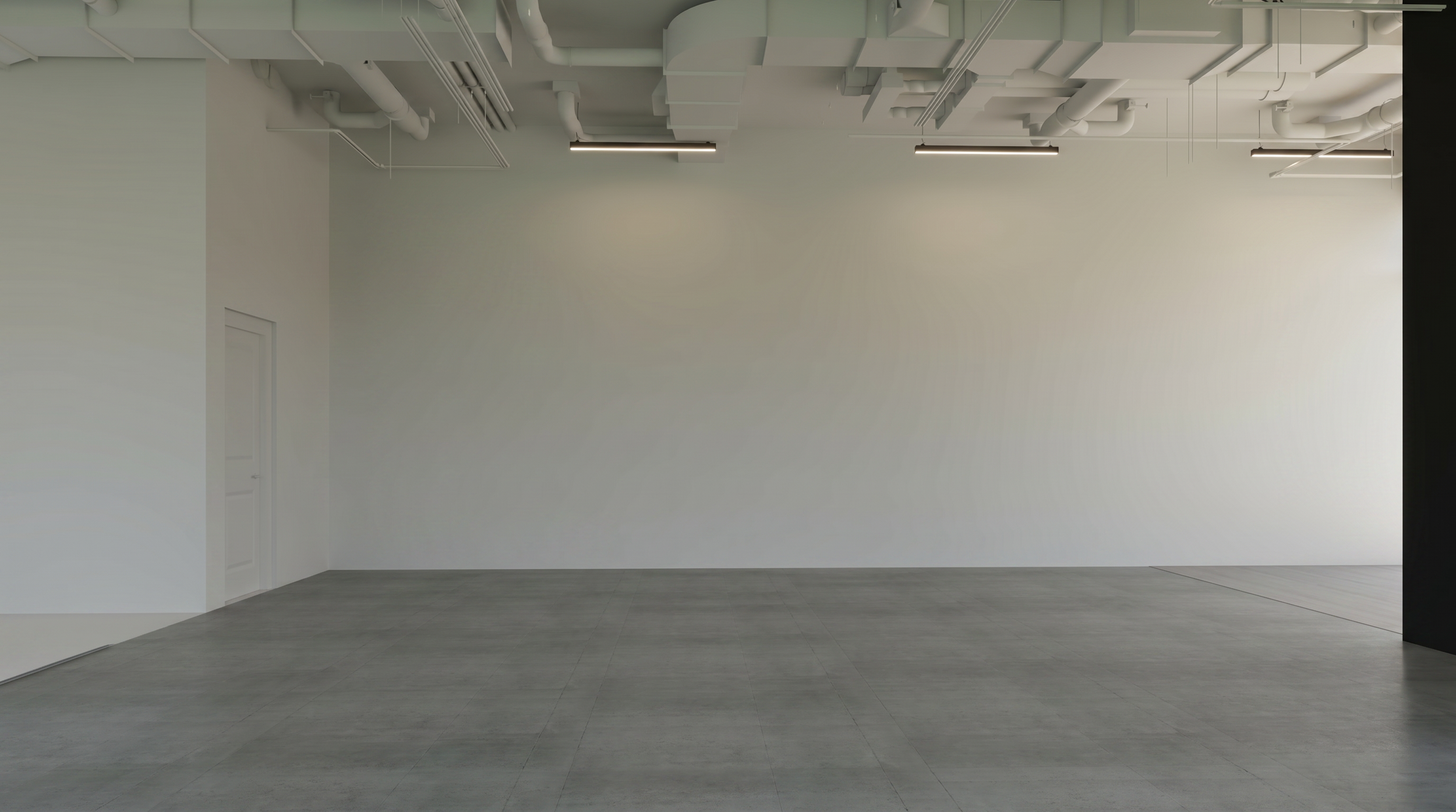 Empty modern room with high white walls, ceiling pipes, and gray tile floor.