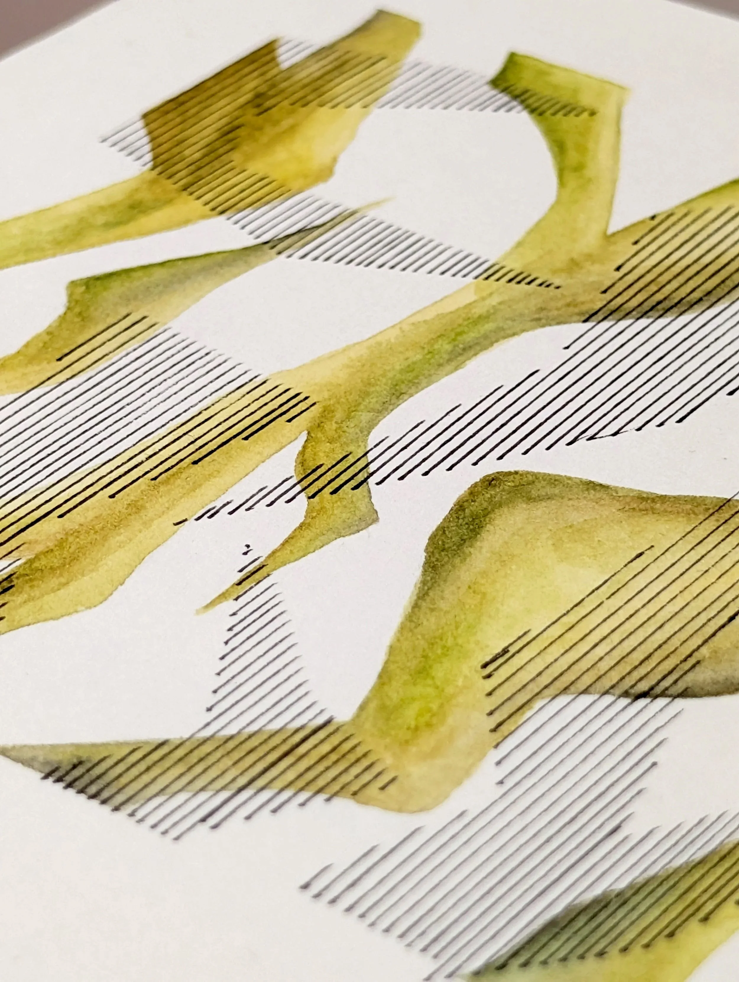 Close-up of a printed abstract design with yellow watercolor-like strokes and black parallel lines on a white background.