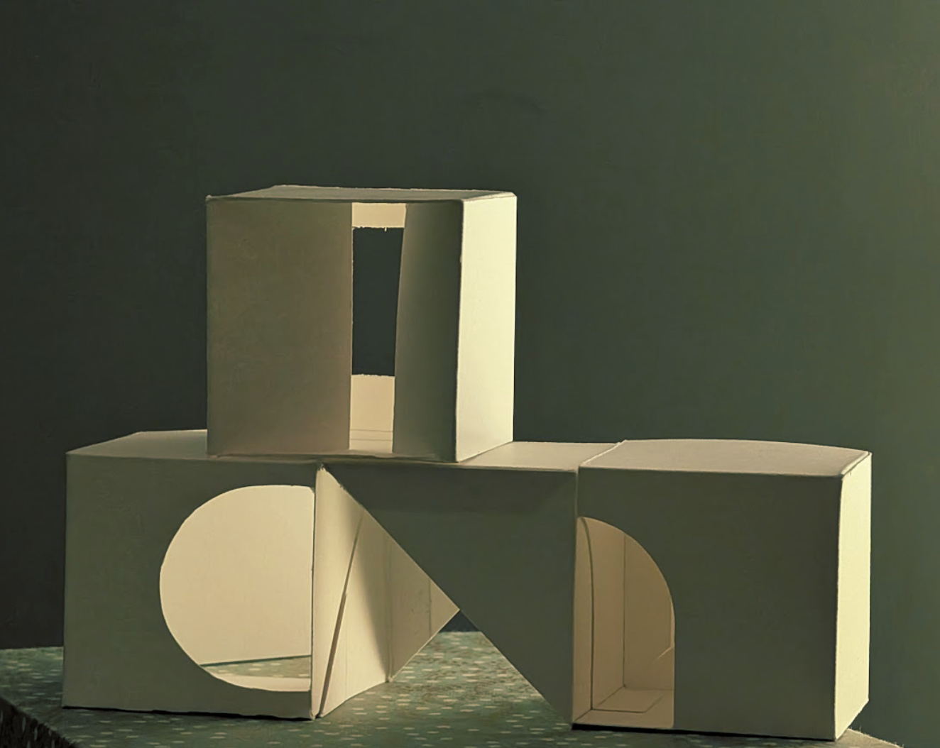 White cardboard three-dimensional geometric paper sculptures with cutout shapes, arranged on a patterned surface against a dark background.