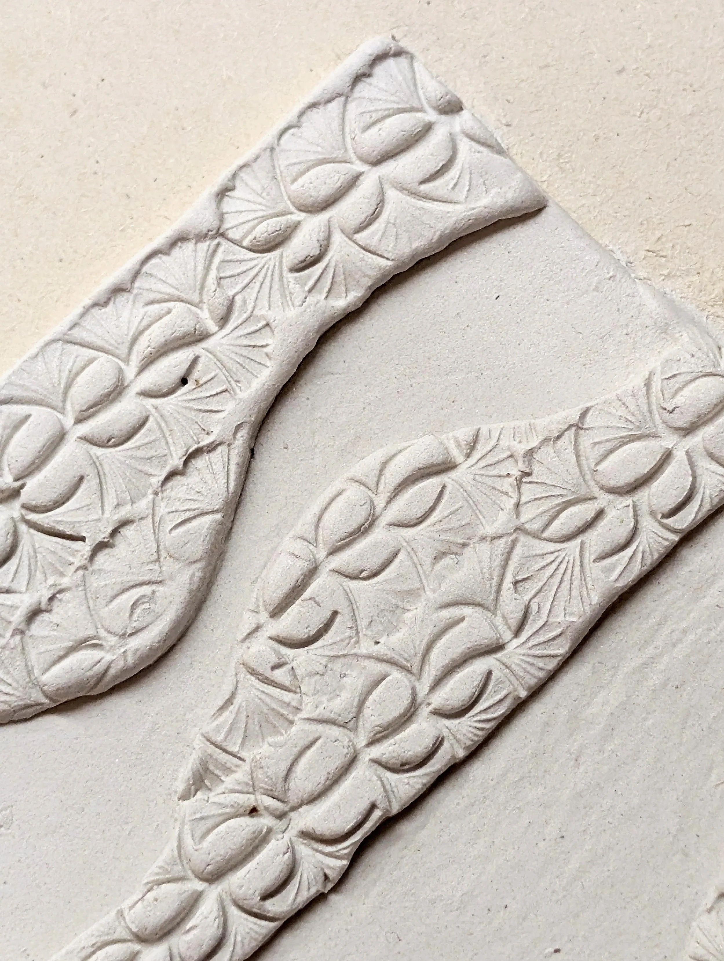 Close-up of an ornate, carved white stone or plaster decorative item with intricate floral patterns.