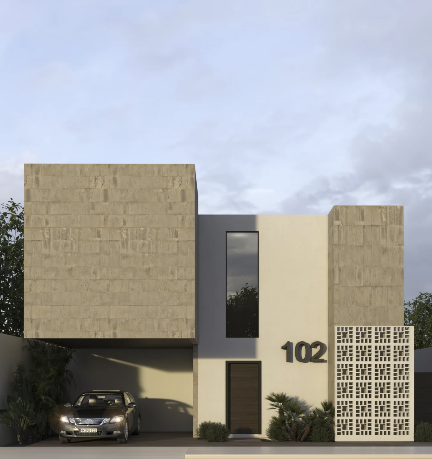 Modern residential house with beige stone walls, a black window, and the number 102 on the wall; a car parked in front, surrounded by desert plants and small bushes, under a cloudy sky.