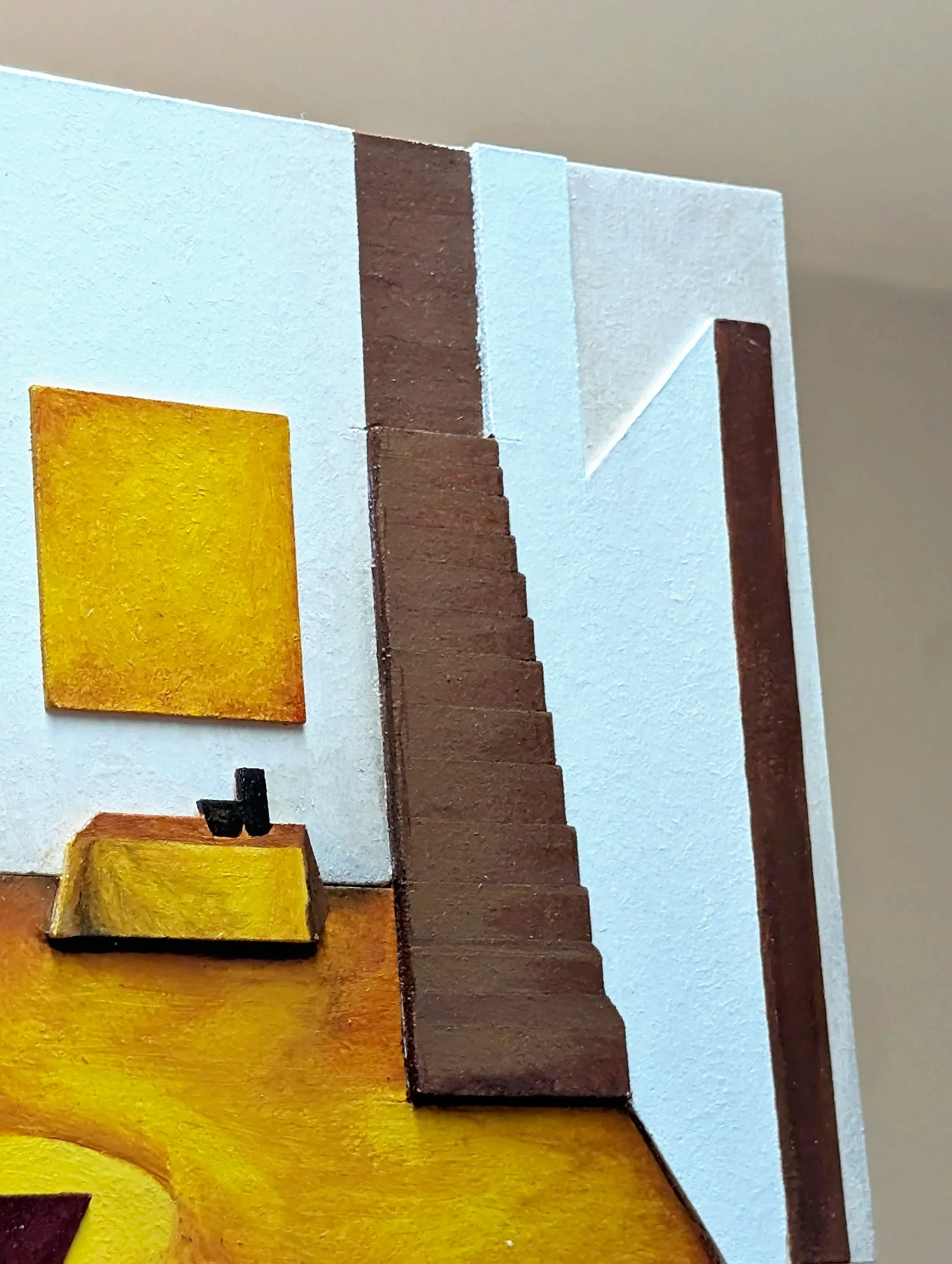 Close-up of a wooden staircase with painted yellow steps, brown walls, and a black handrail.
