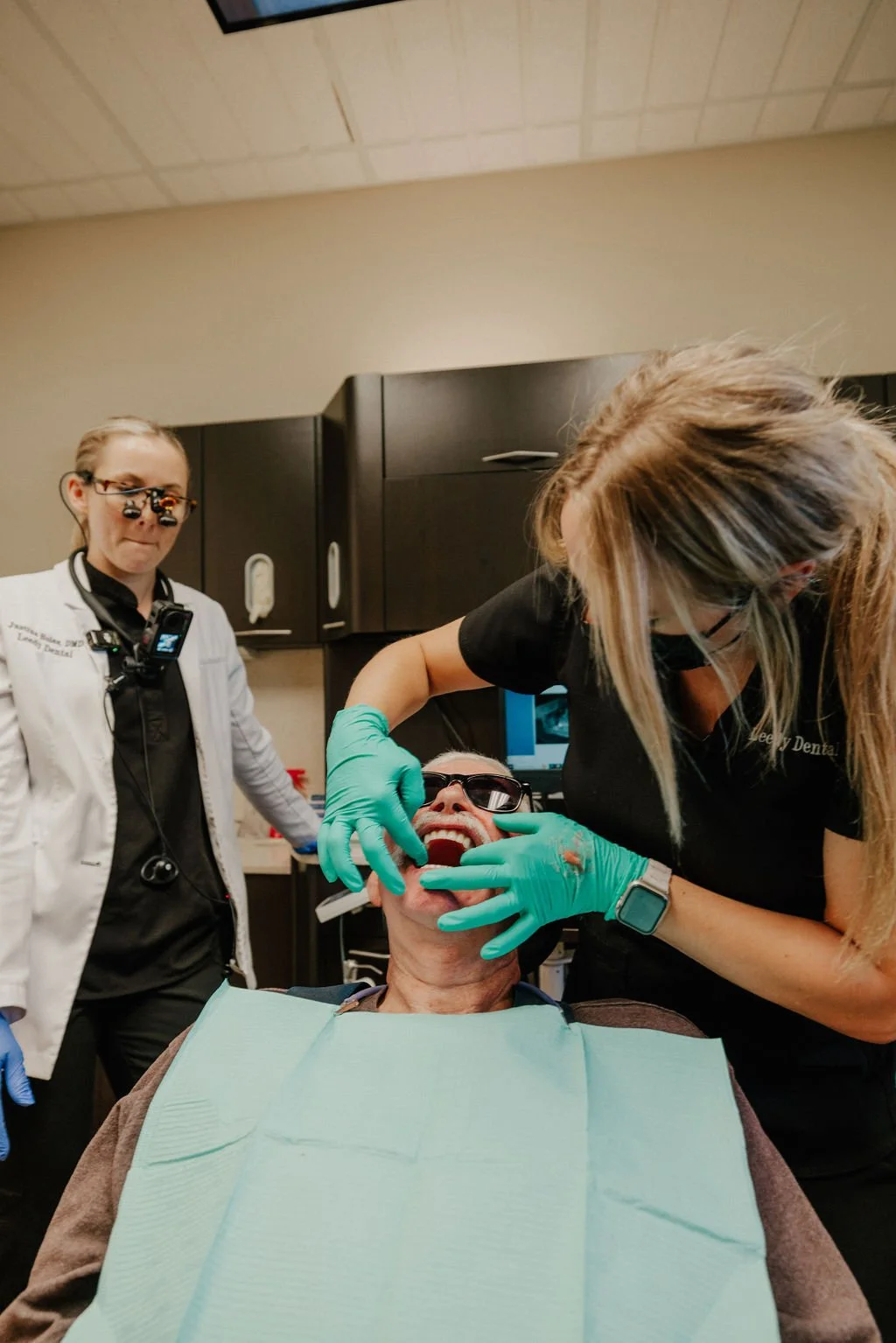 Dental professionals examining a patient in a dental clinic.