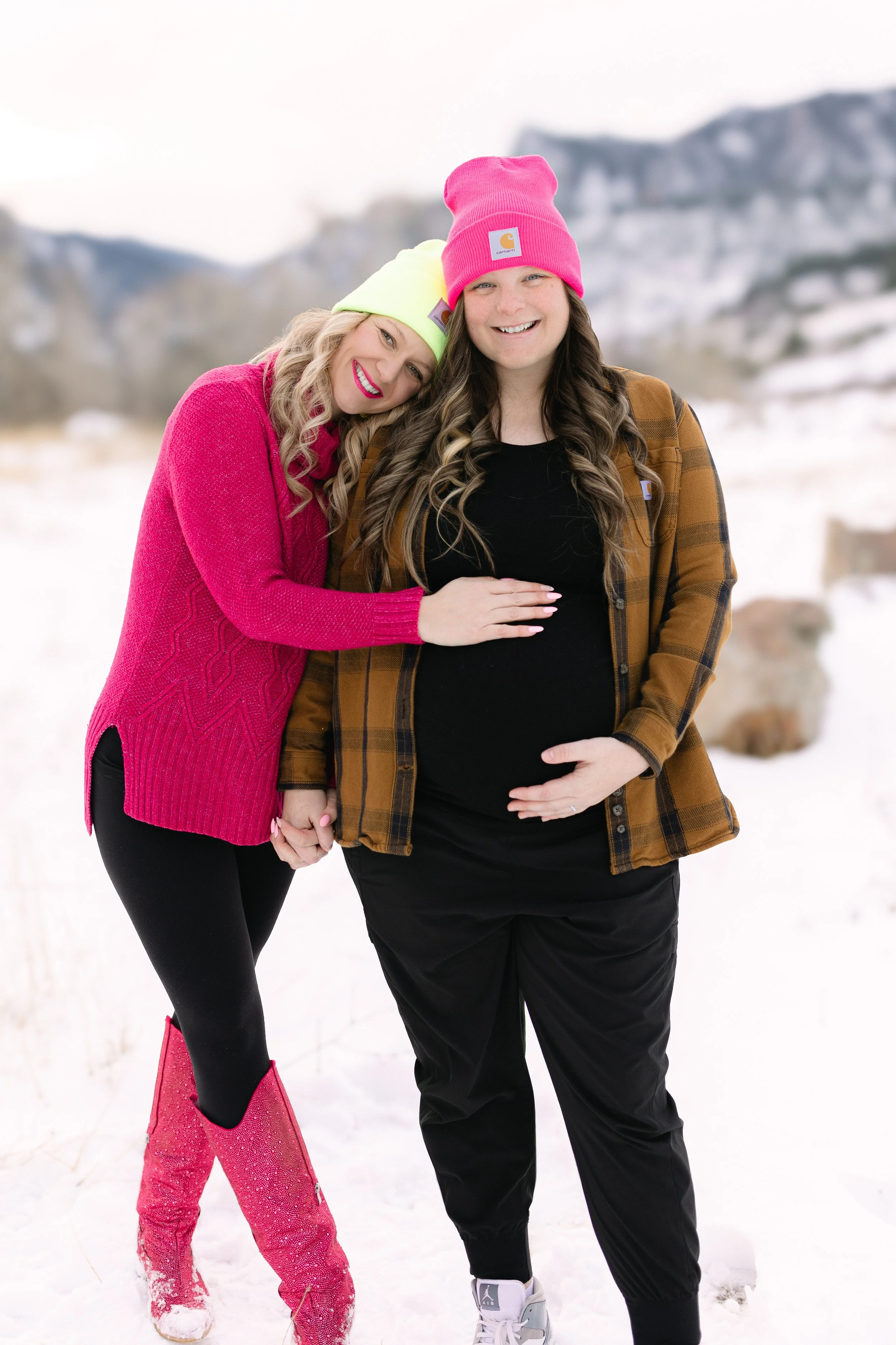  black and white maternity photo capturing a genuine, emotional moment between an expecting mother and her partner. The mother gently holds her baby bump while sharing a smile, highlighting the connection, anticipation, and love during this special s