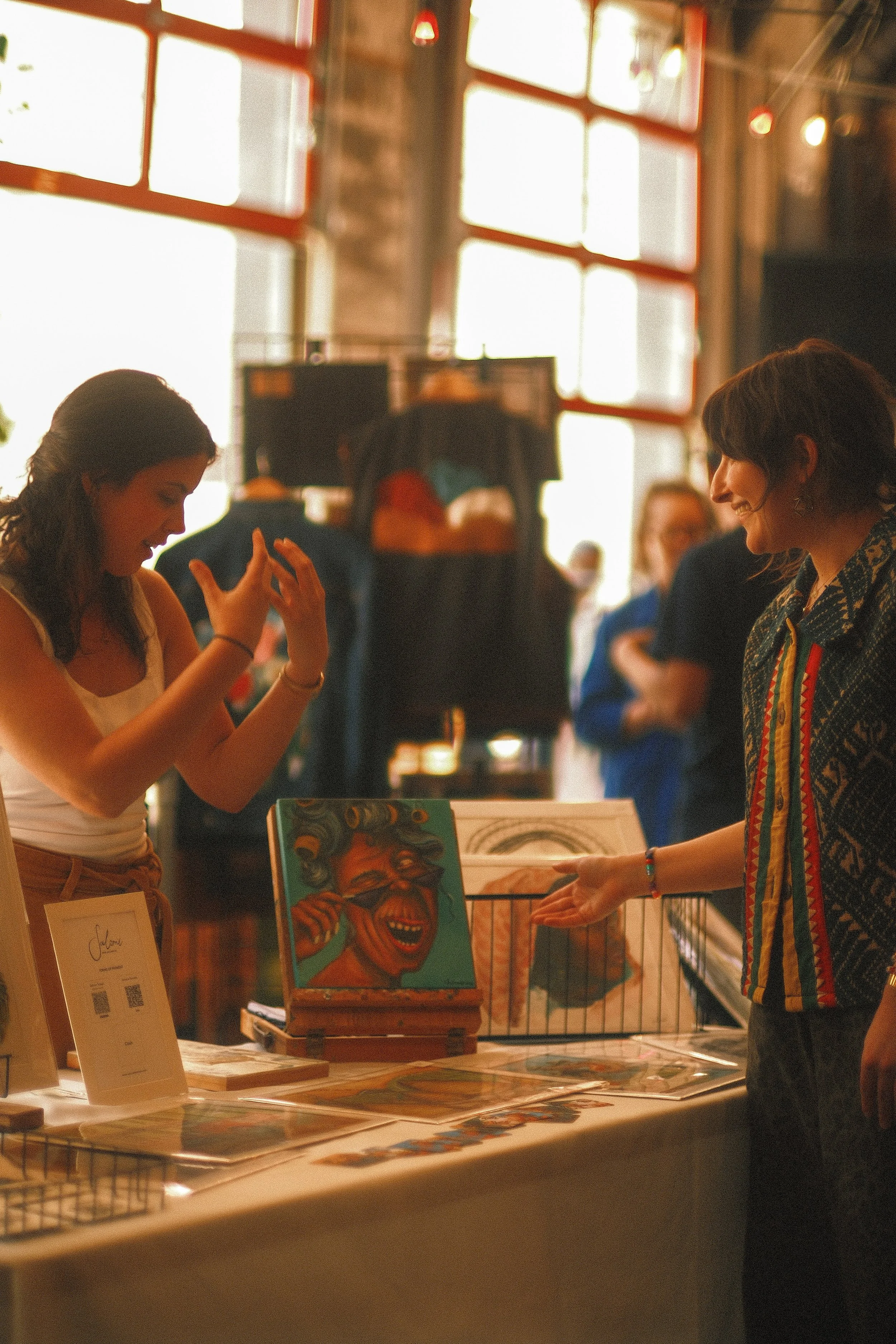 Amy chats with an artist vending at the Spring Cleaning art market, which was hosted by LOAM in Philly in May 2026