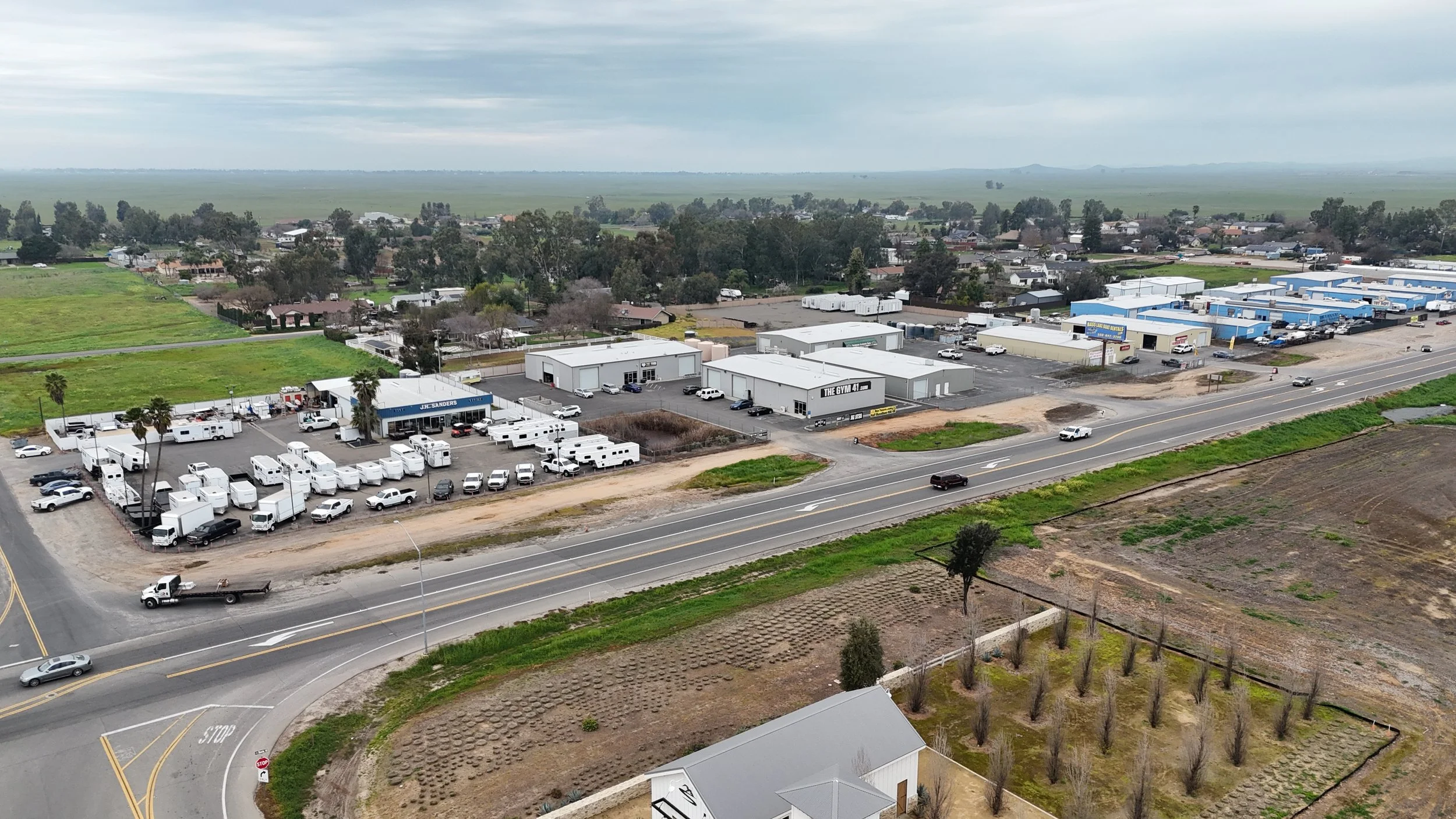 There is an intersection on the bottom left corner of the image. The right side of the intersection continues from the bottom left corner to the far east side. There are building on the northeast side of the intersection that continues to the far rig