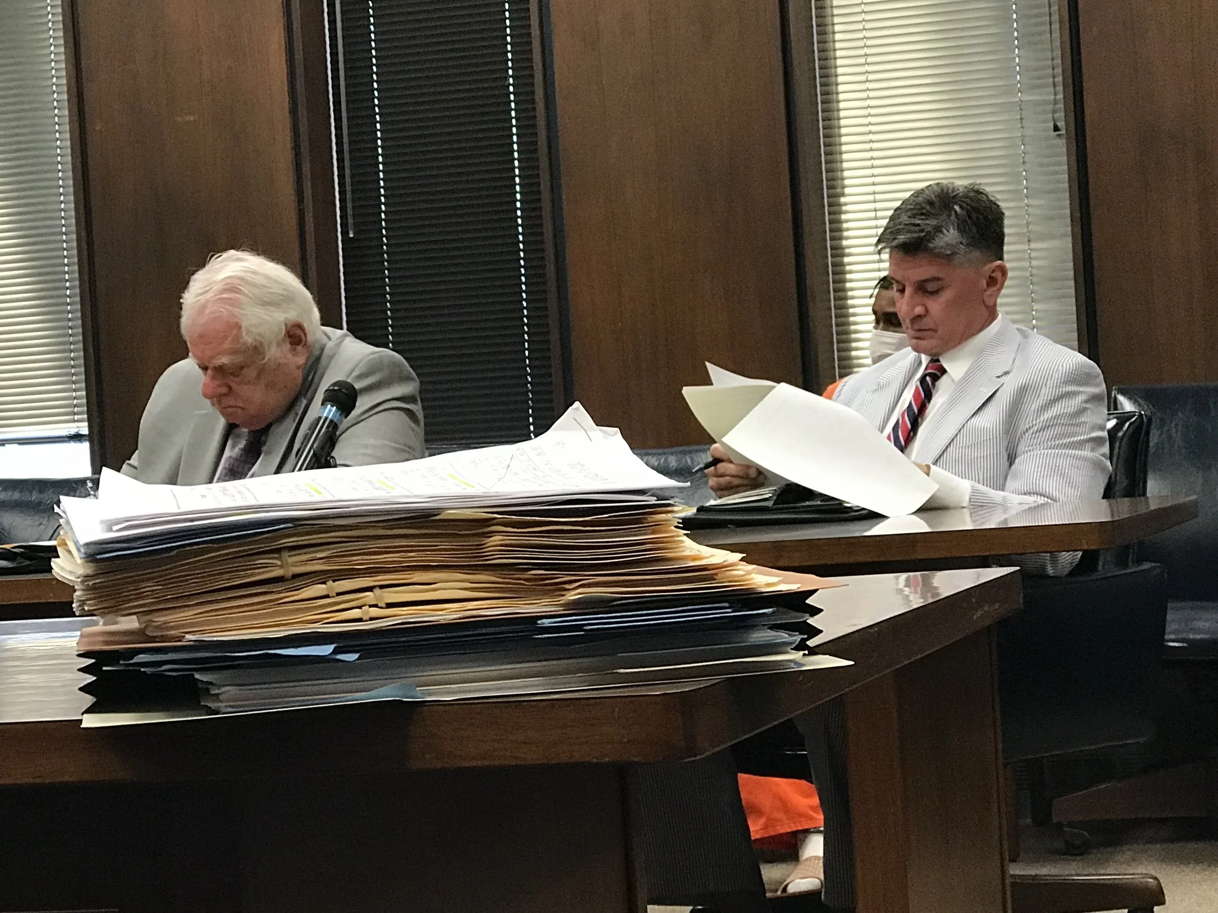 People sitting at a table reviewing documents in a courtroom..