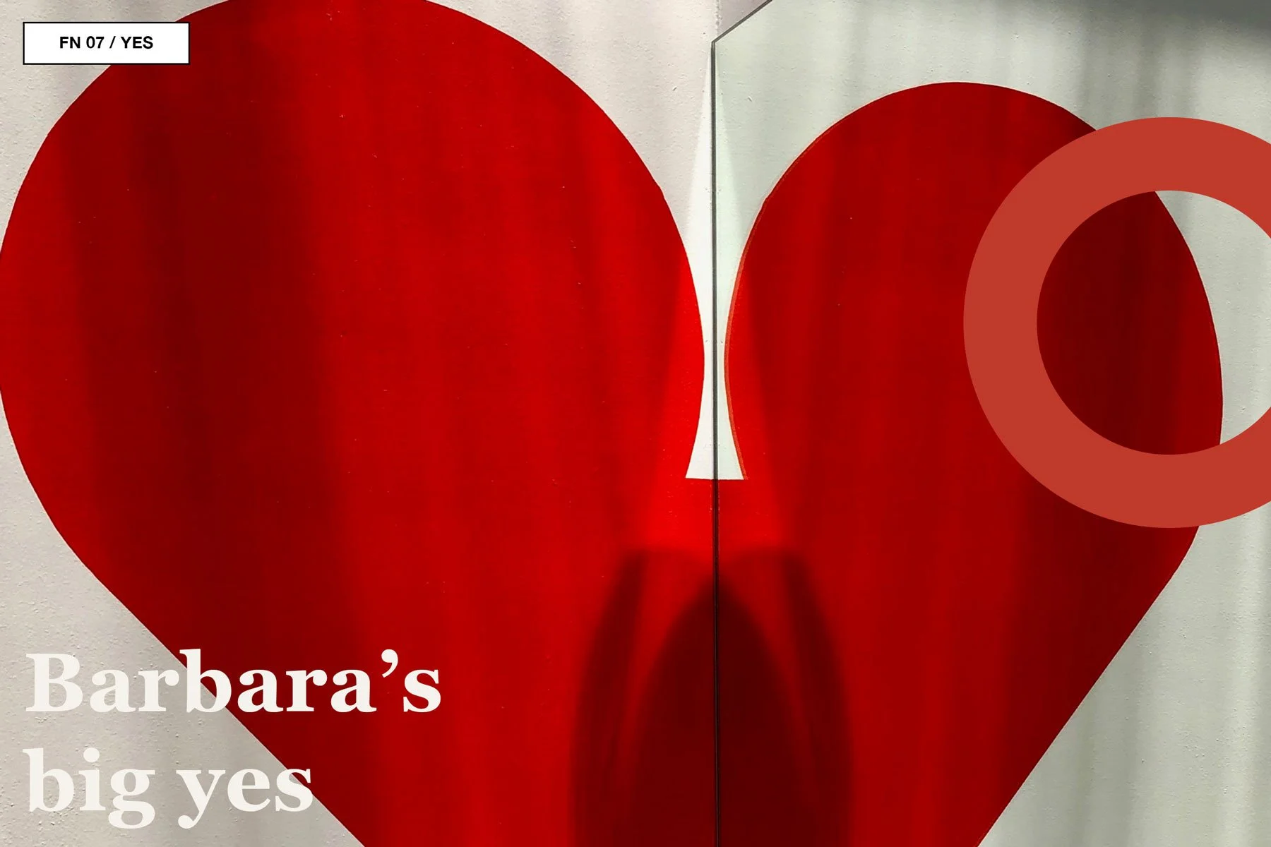 Large red heart supergraphic painted across a pale interior wall and mirror.