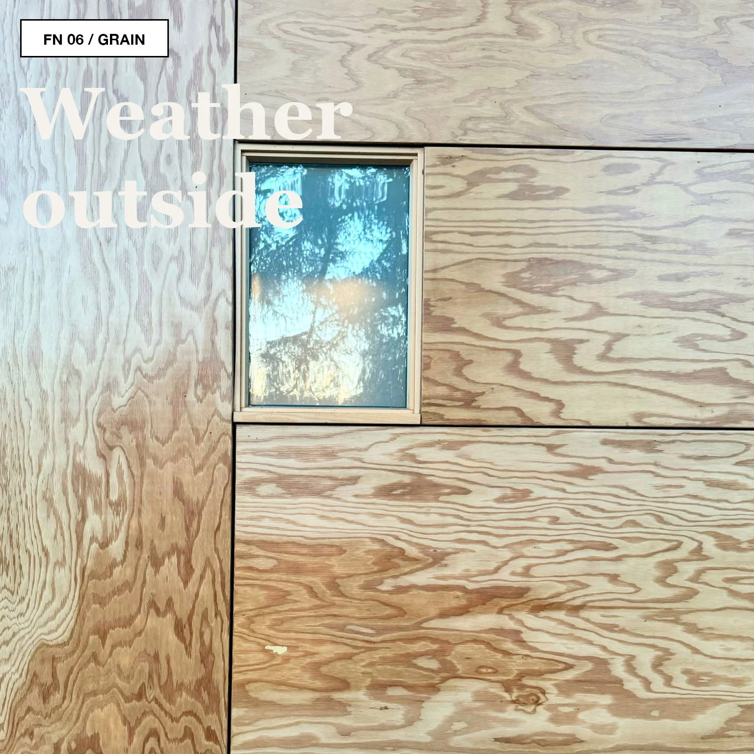Plywood interior wall with a small window and warm light inside a Jyubako cabin at Snow Peak Campfield.