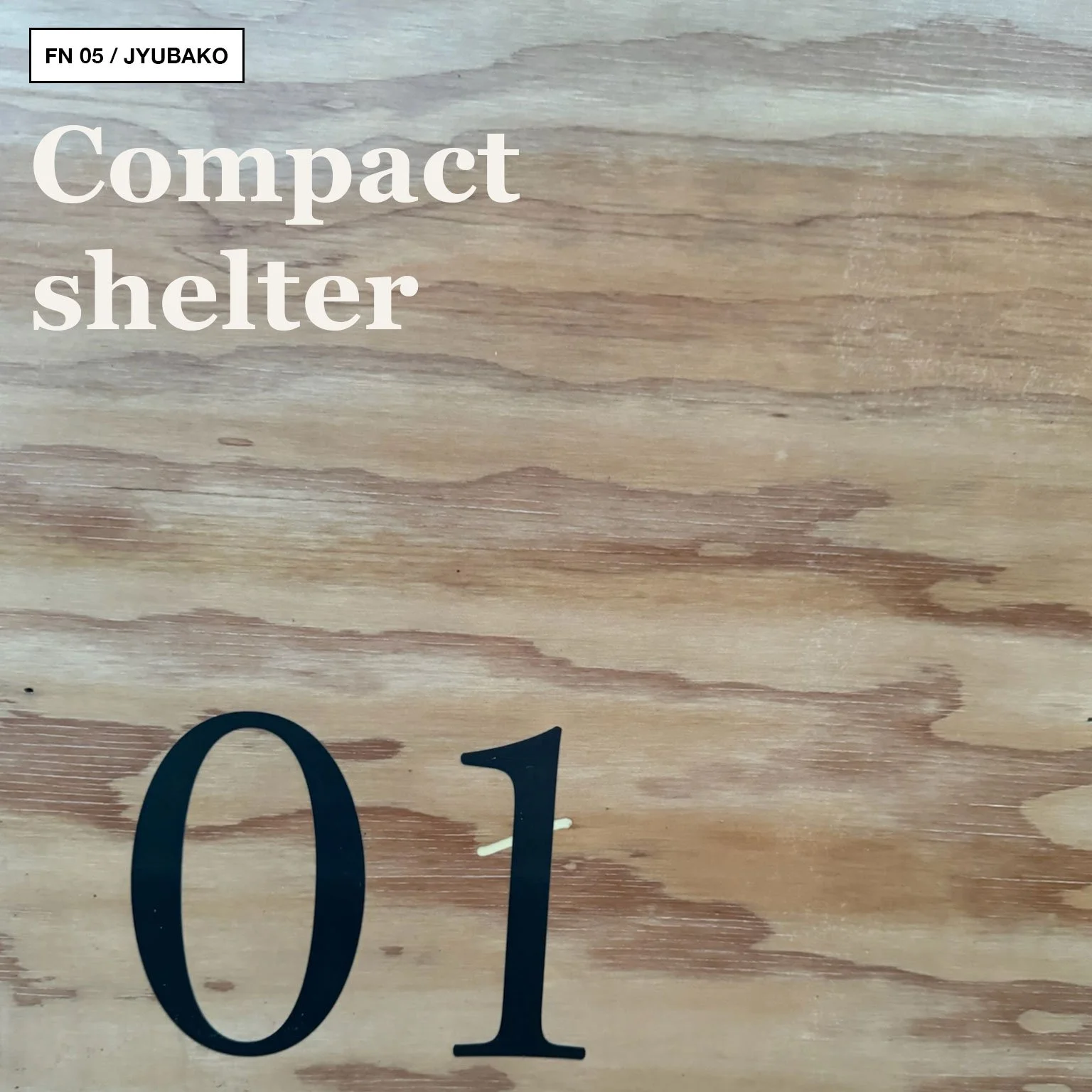 Close-up of pale plywood wall marked “01 Jyubako” inside a Snow Peak cabin.