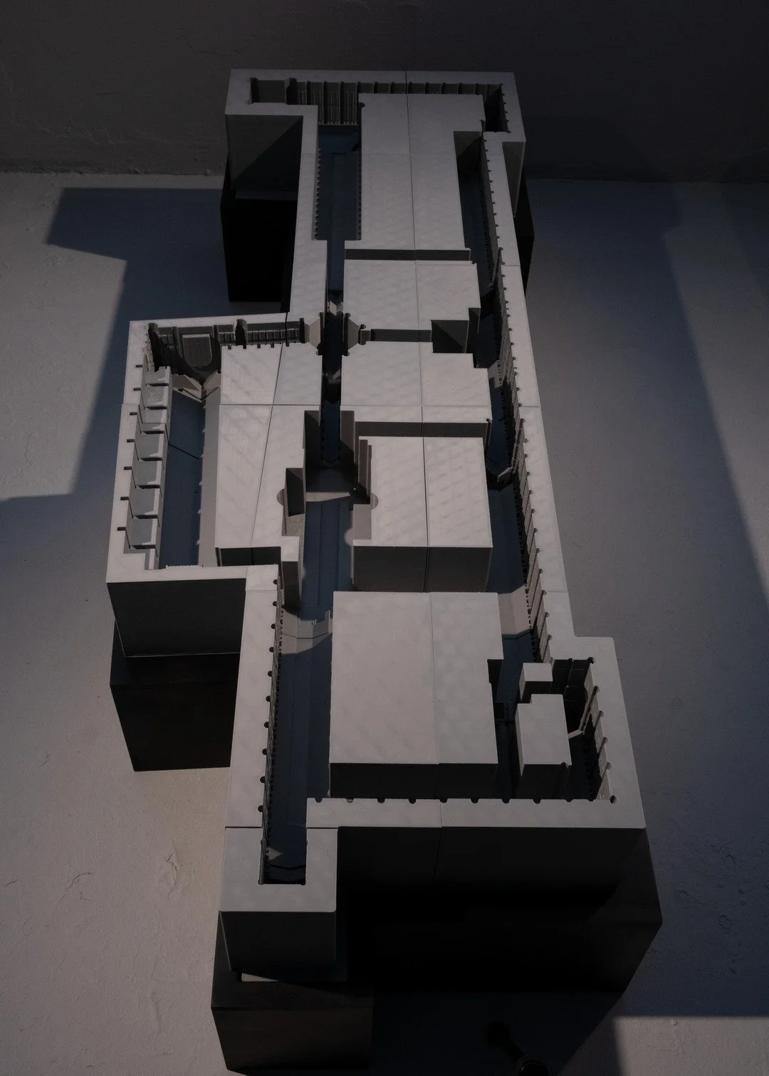 A scale model of a modern building complex with multiple levels and enclosed courtyards, viewed from above.