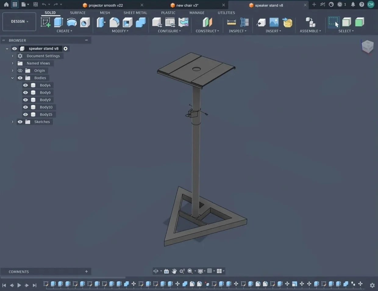 A 3D CAD design of a speaker stand with a triangular base, a vertical support, and a flat top surface with a hole in the center, displayed on a computer screen using CAD software.