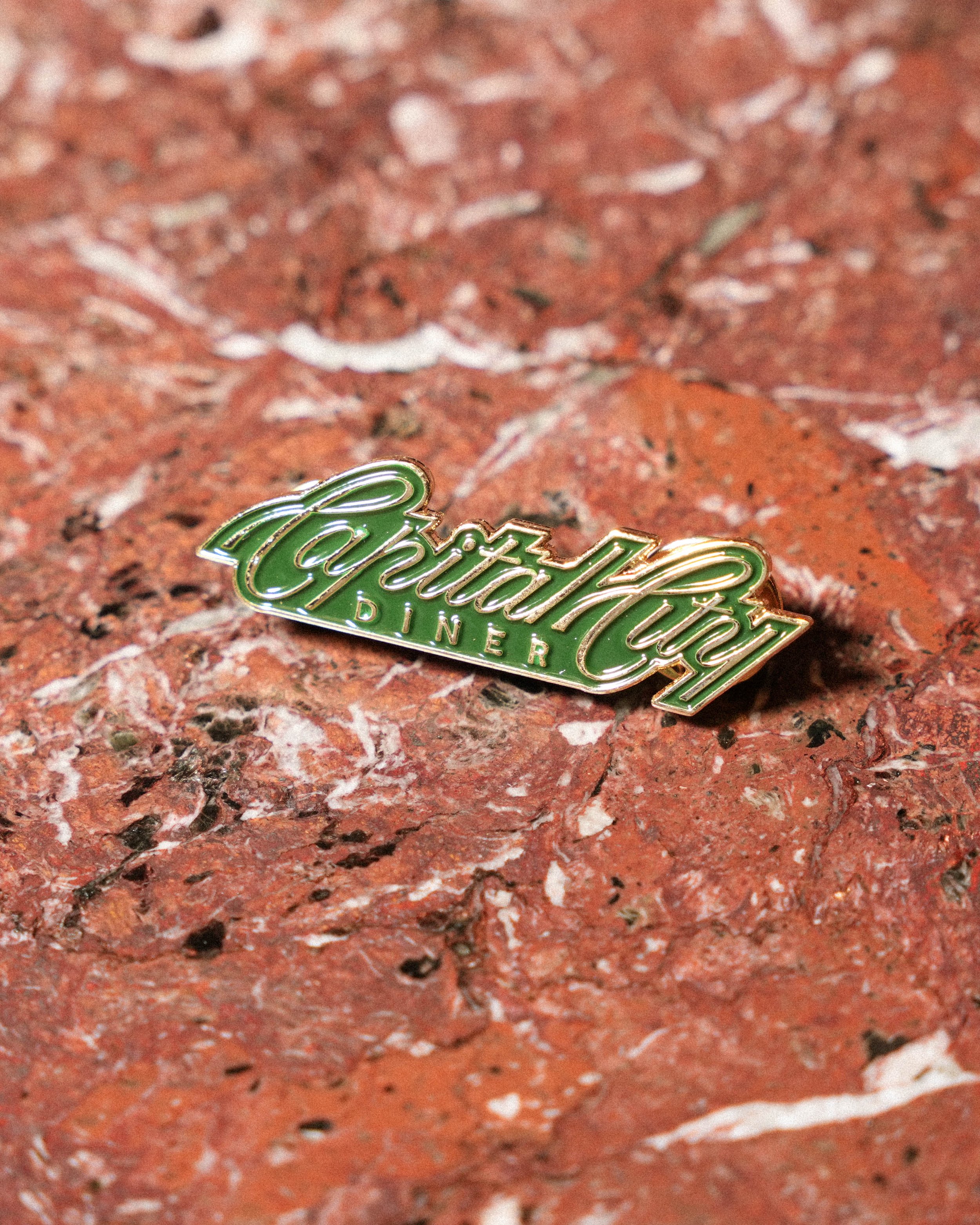 Close-up of a brick surface with a vintage-style Coca-Cola badge in the foreground.