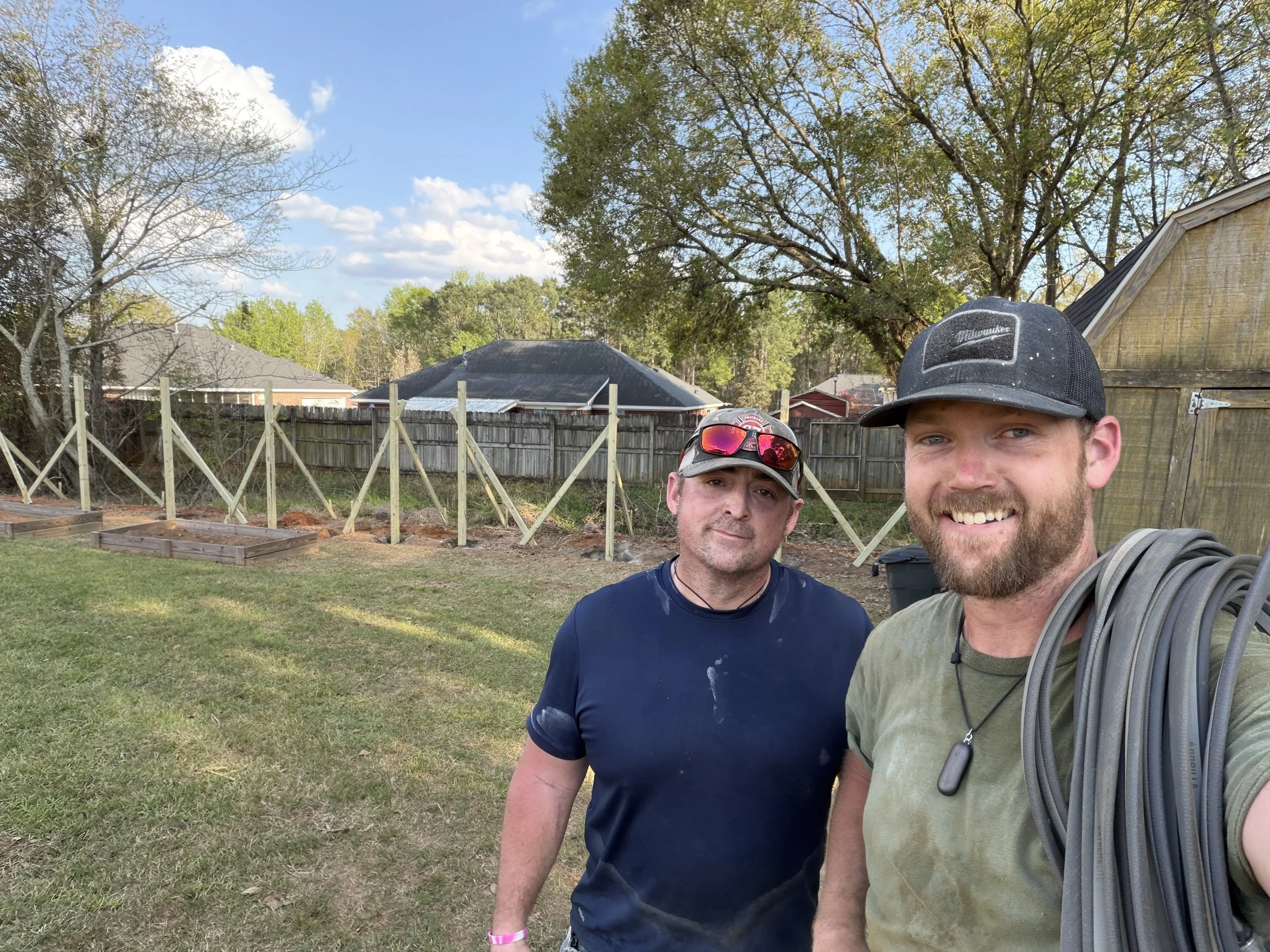 The Founder of Noah's Hammer and a team member after a long day of work on a fence installation.