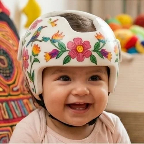 Niña con casco de bicicleta decorado con flores y pájaros, sonriendo.