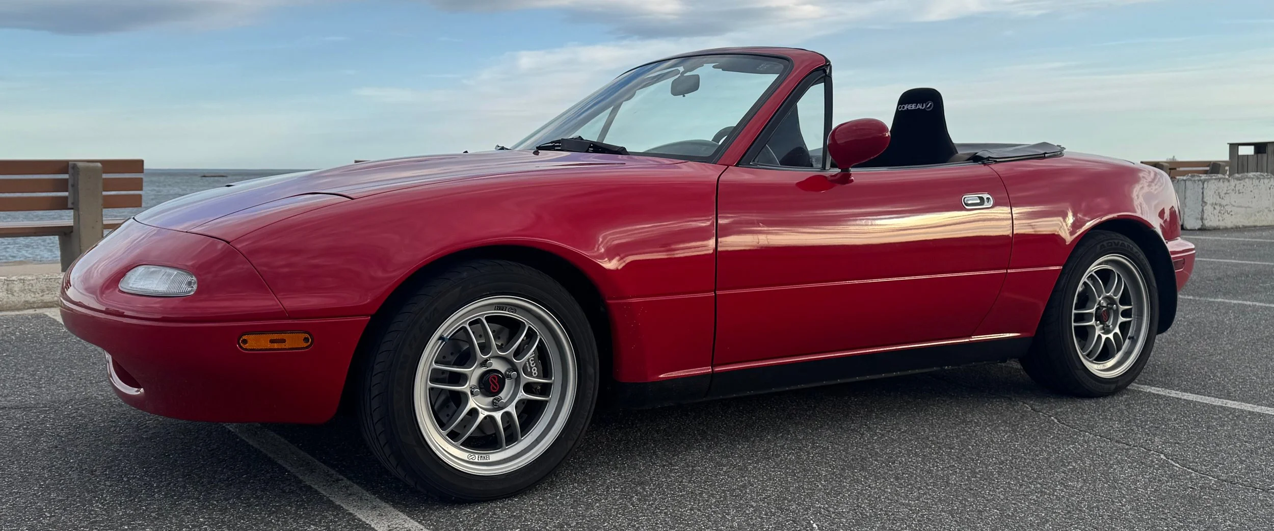 Classic red 1990 NA Mazda Miata MX-5. Link leads to the NA section of website.