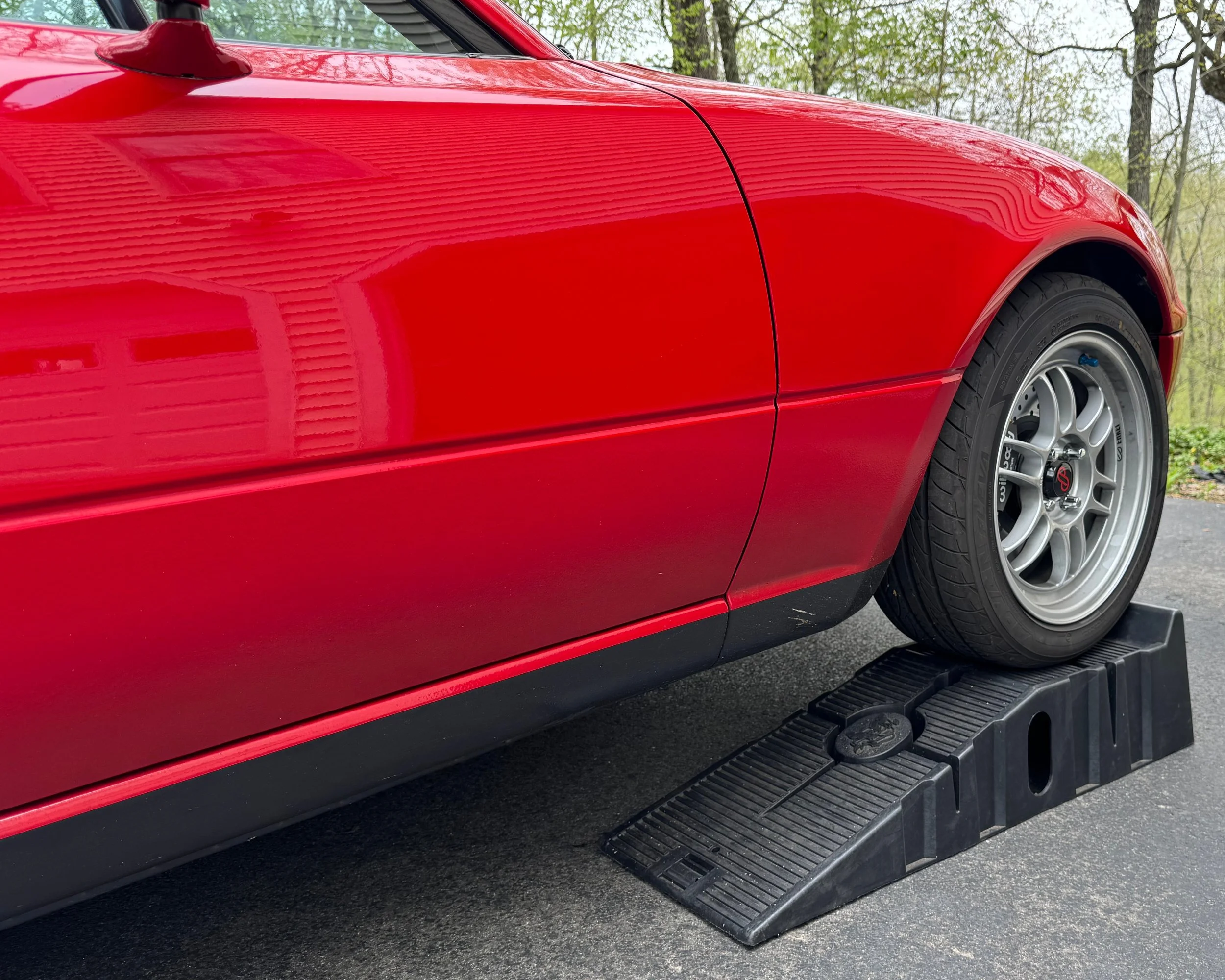 NA Mazda Miata MX-5 classic red on ramps. The front end of the car is up on the ramps