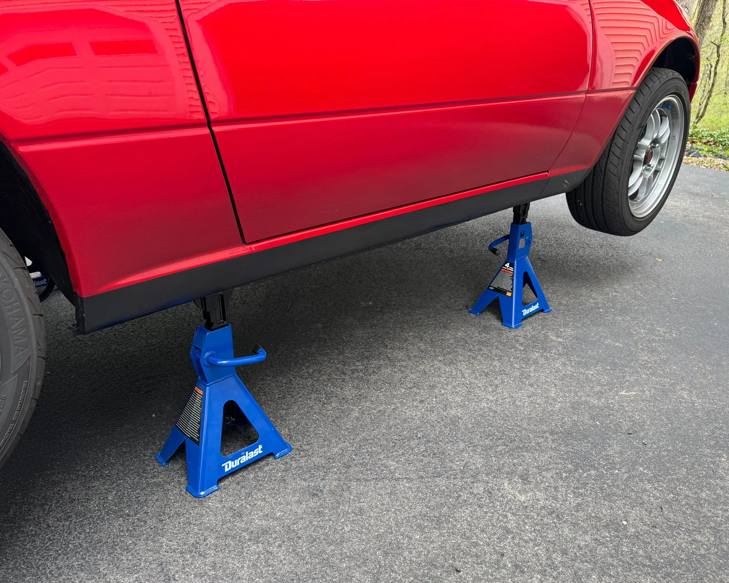 NA Mazda Miata MX-5 classic red on two jack stands in driveway